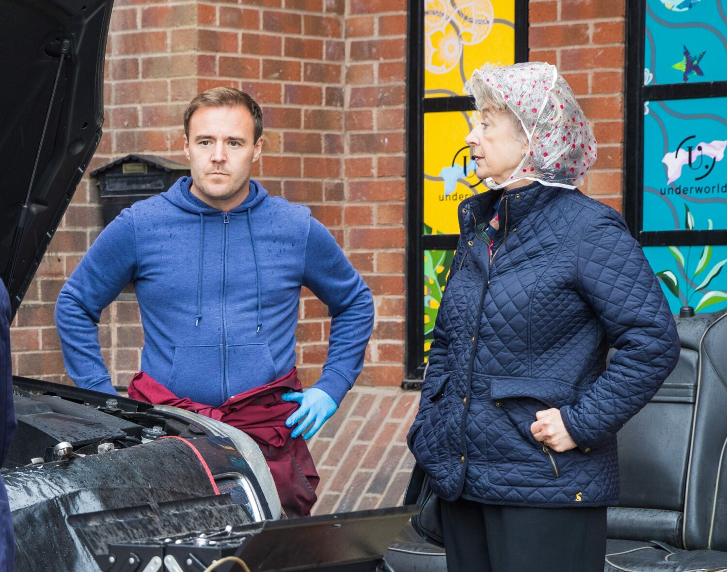 Coronation Street's Tyrone has his hands on his hips as he speaks to Evelyn at the garage