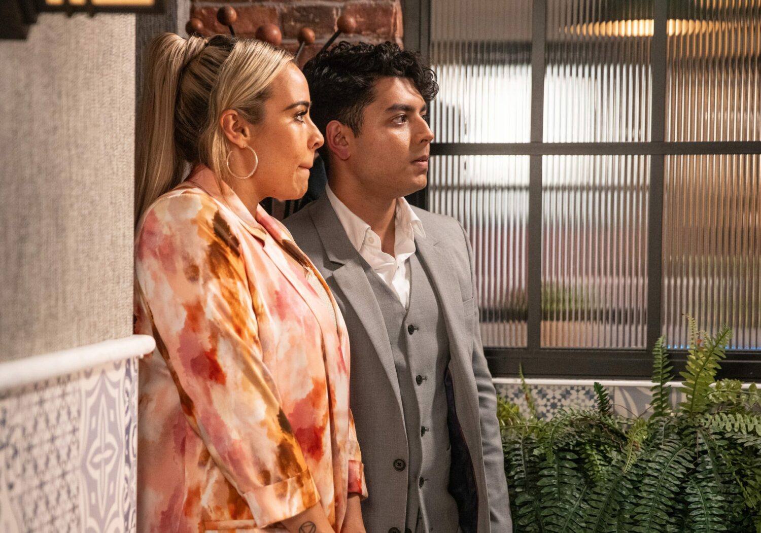 Coronation Street's Courtney and Aadi are looking shifty as they stand by a wall