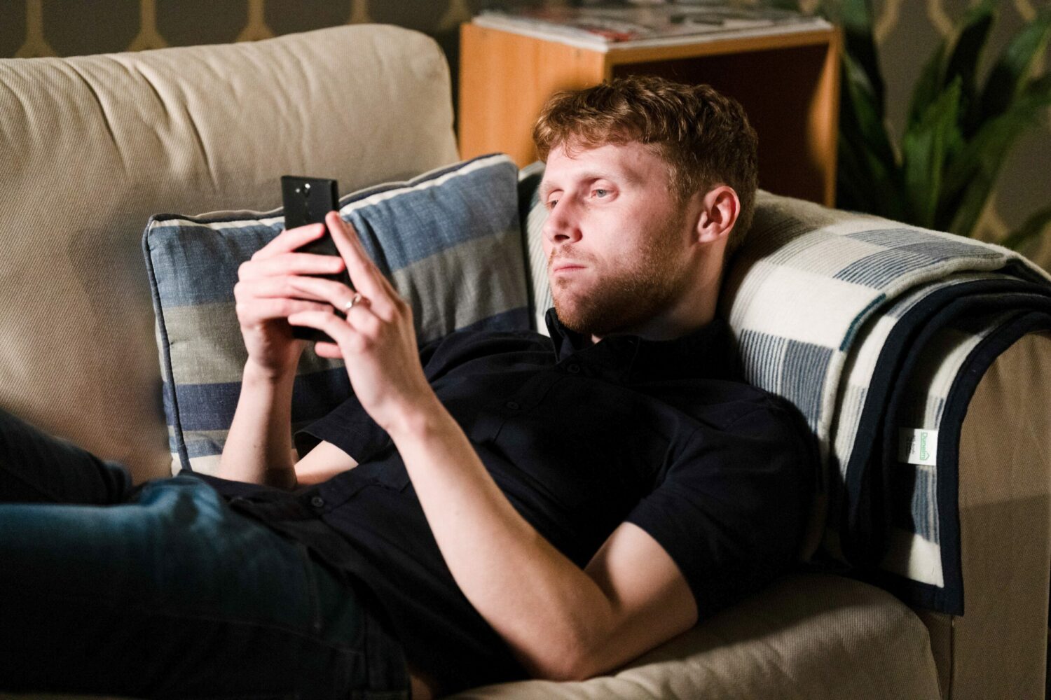 Jay in EastEnders looks at his phone