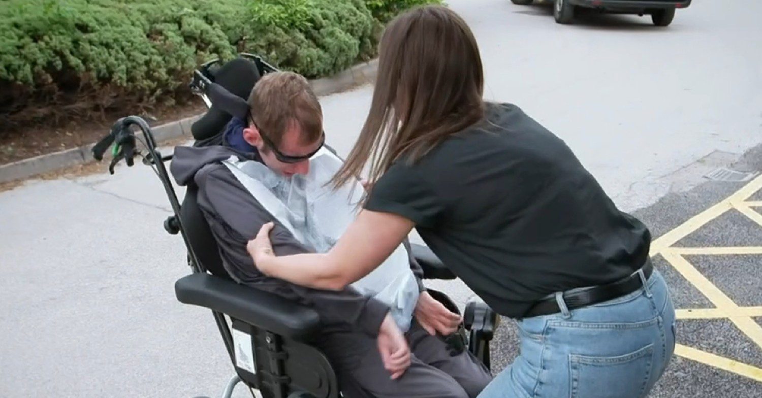 Rob Burrow is lifted out of his wheelchair by his wife Lindsey Burrow