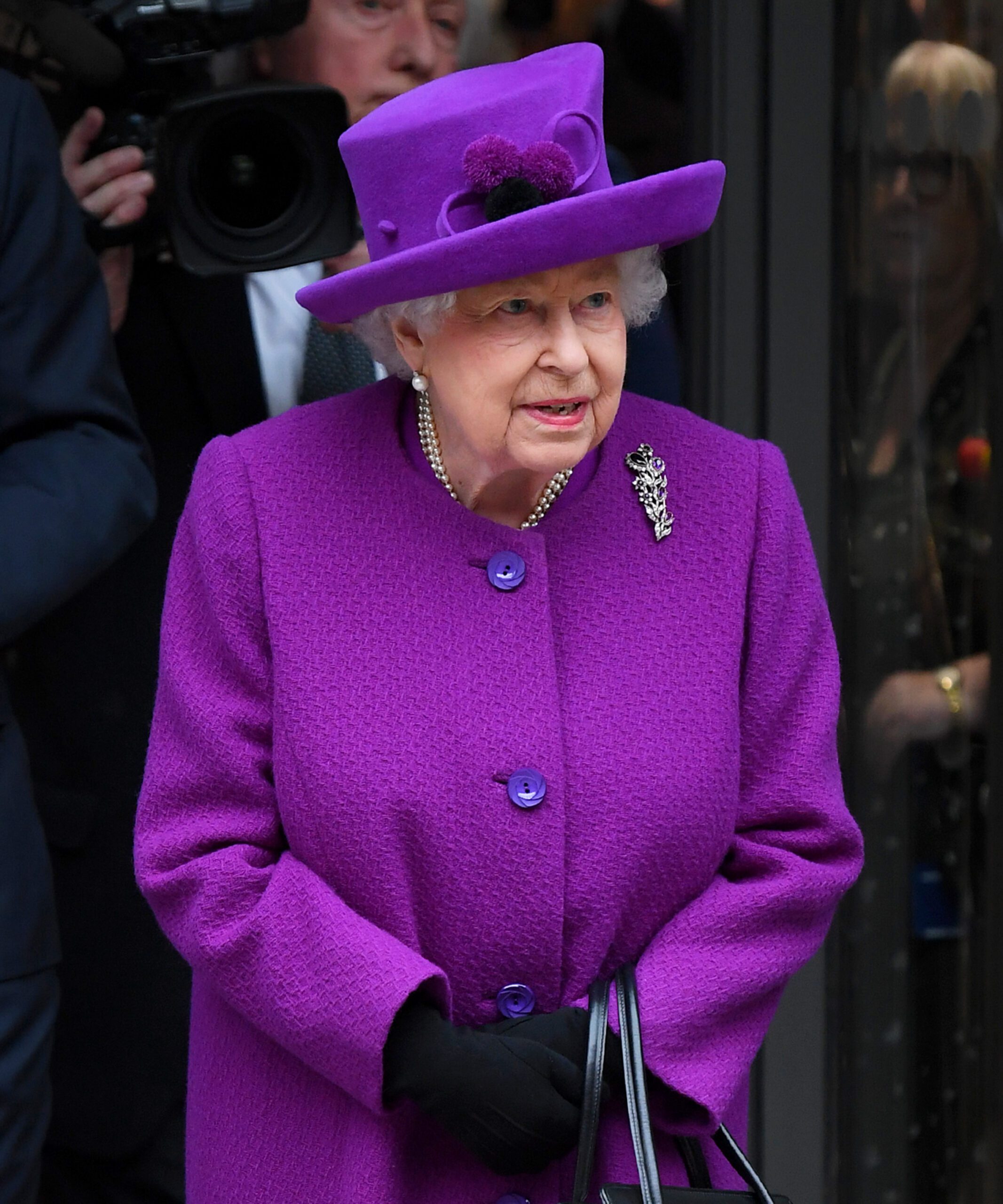 The Queen wearing a purple hat and matching coat