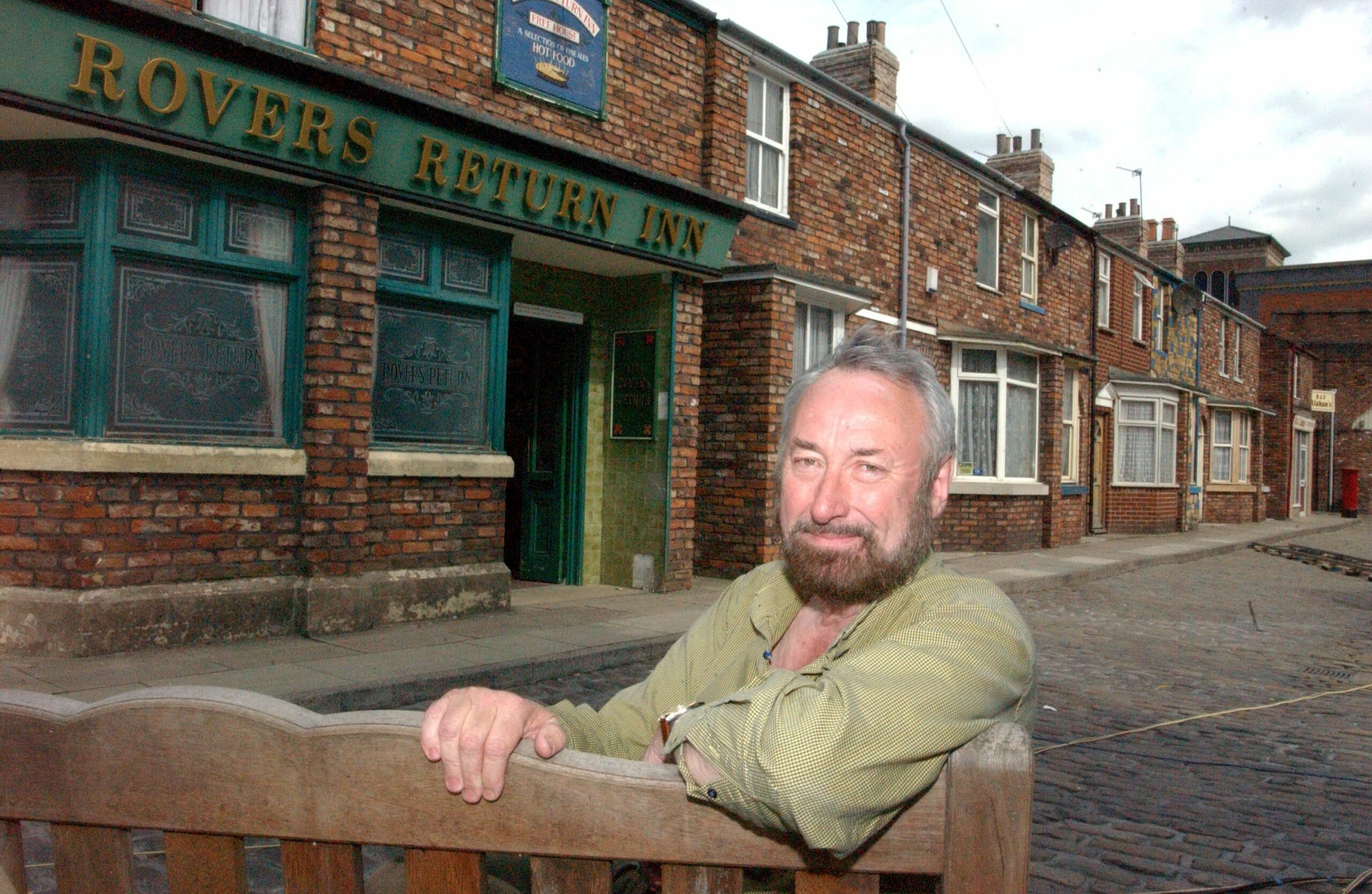 John Stevenson sits on a bench on the cobbles outside the Rovers Return in Coronation Street