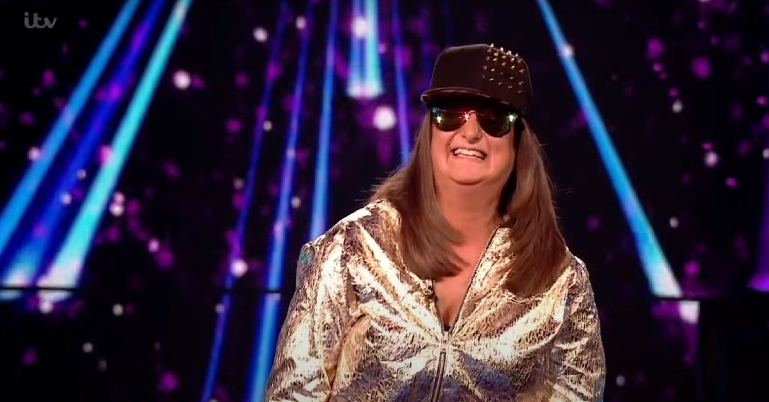 Honey G singing on X Factor wearing sun glasses and a gold jacket