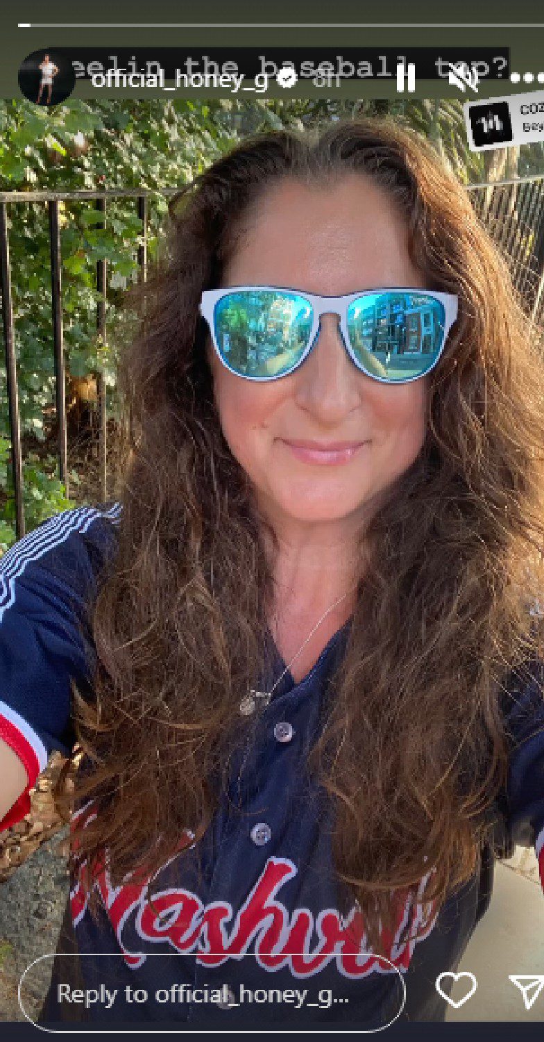 Honey G with her hair down and sun glasses on smiling