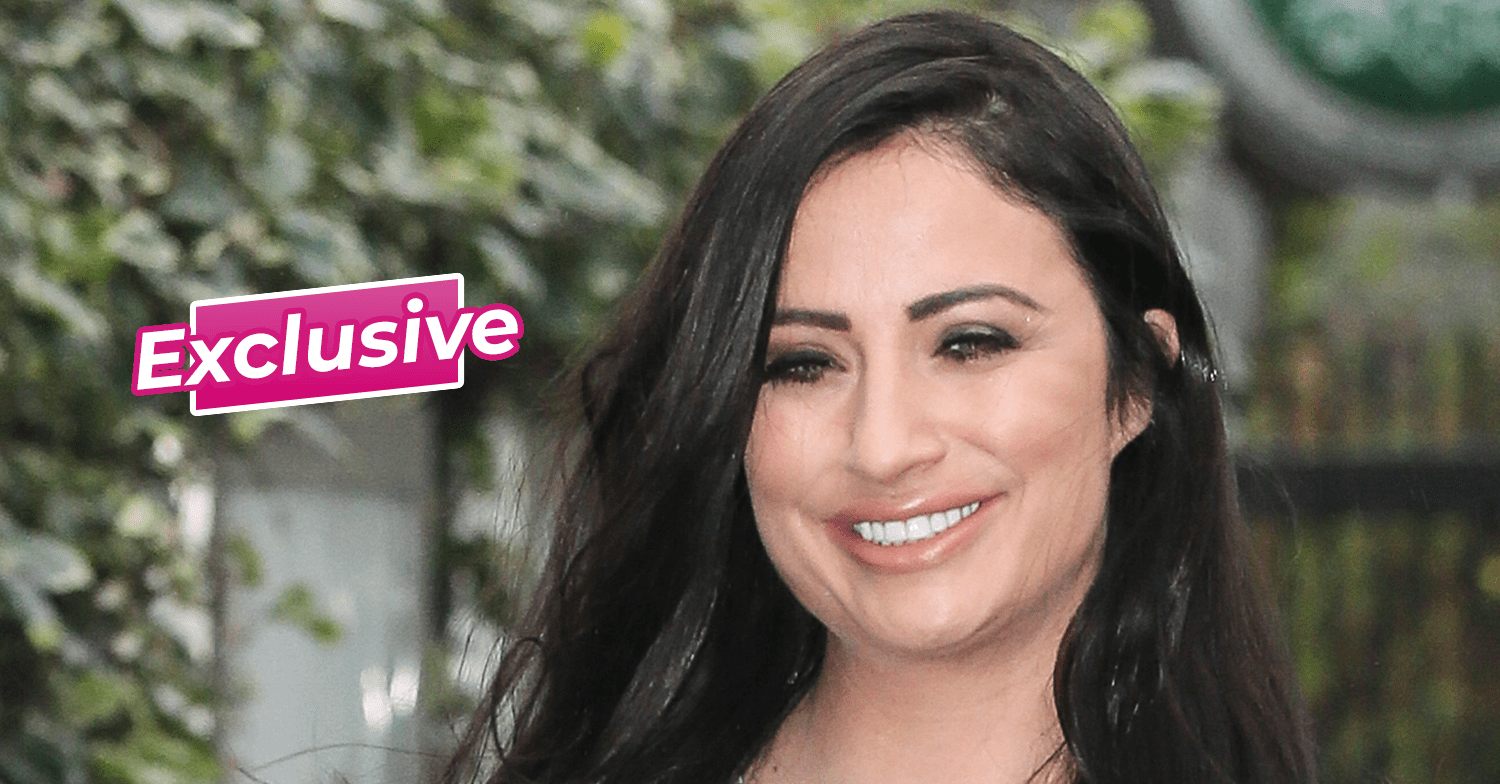 Chantelle Houghton from Big Brother smiling in front of a leafy plant