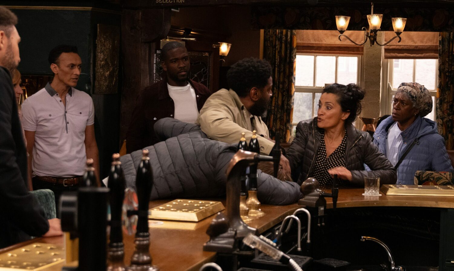 Manpreet desperately pulls Charles back off Tom as he's pinning him to the bar in Emmerdale