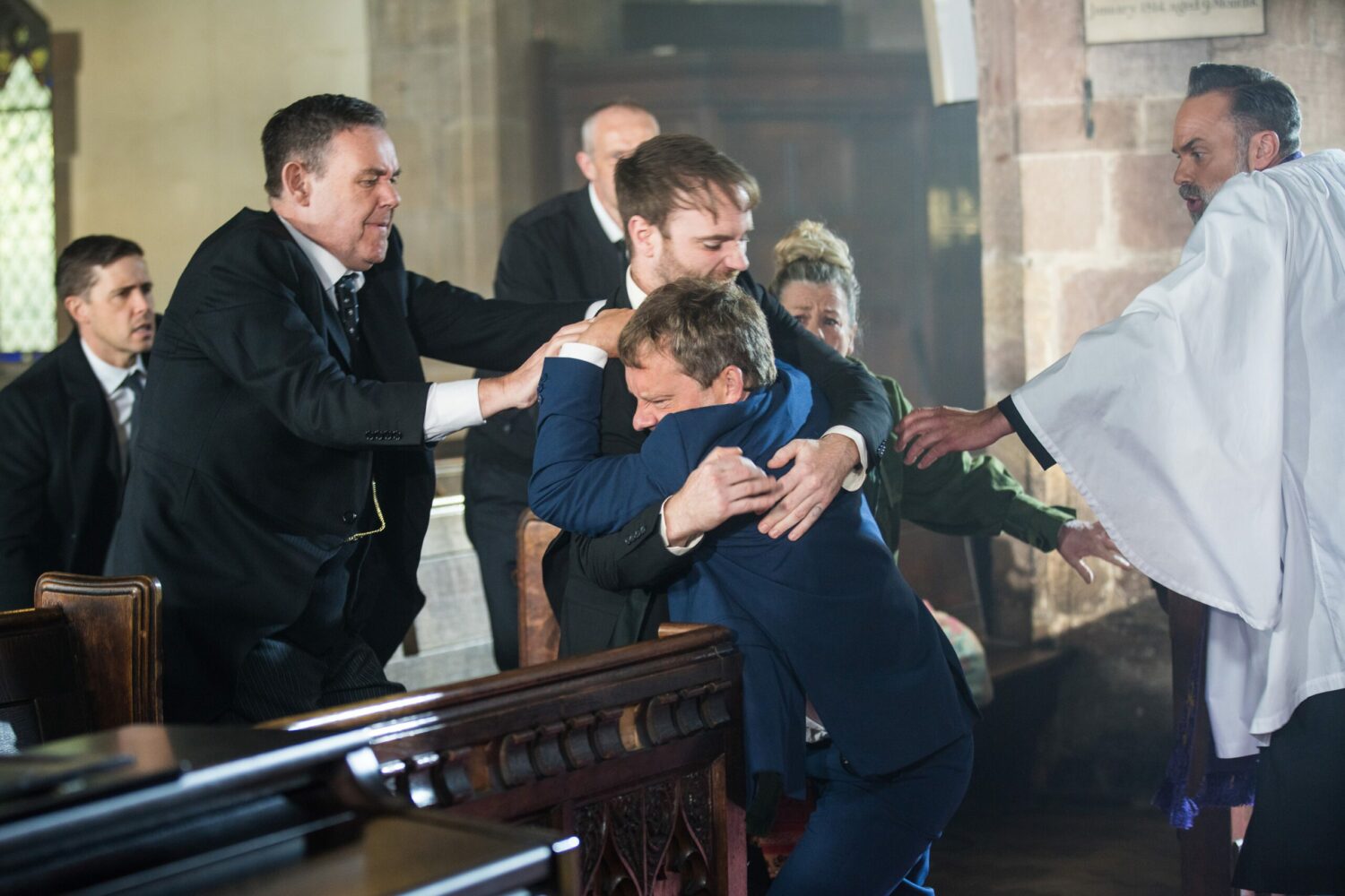 George in Corrie tries to pull Paul and Kieran apart as the fight in church at the funeral