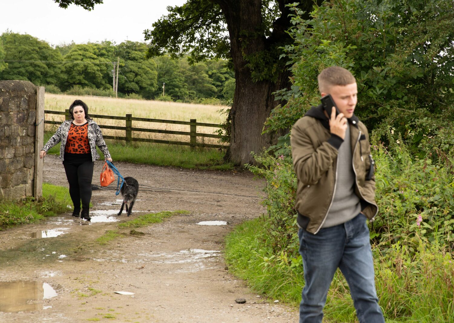Emmerdale's Mandy is walking the dog whilst looking at Samson who is on the phone