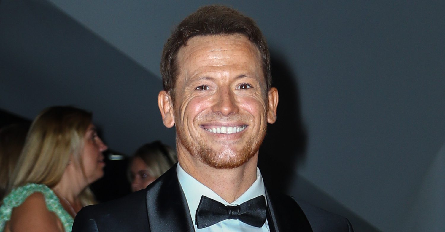 EastEnders' Joe Swash is smiling in a suit