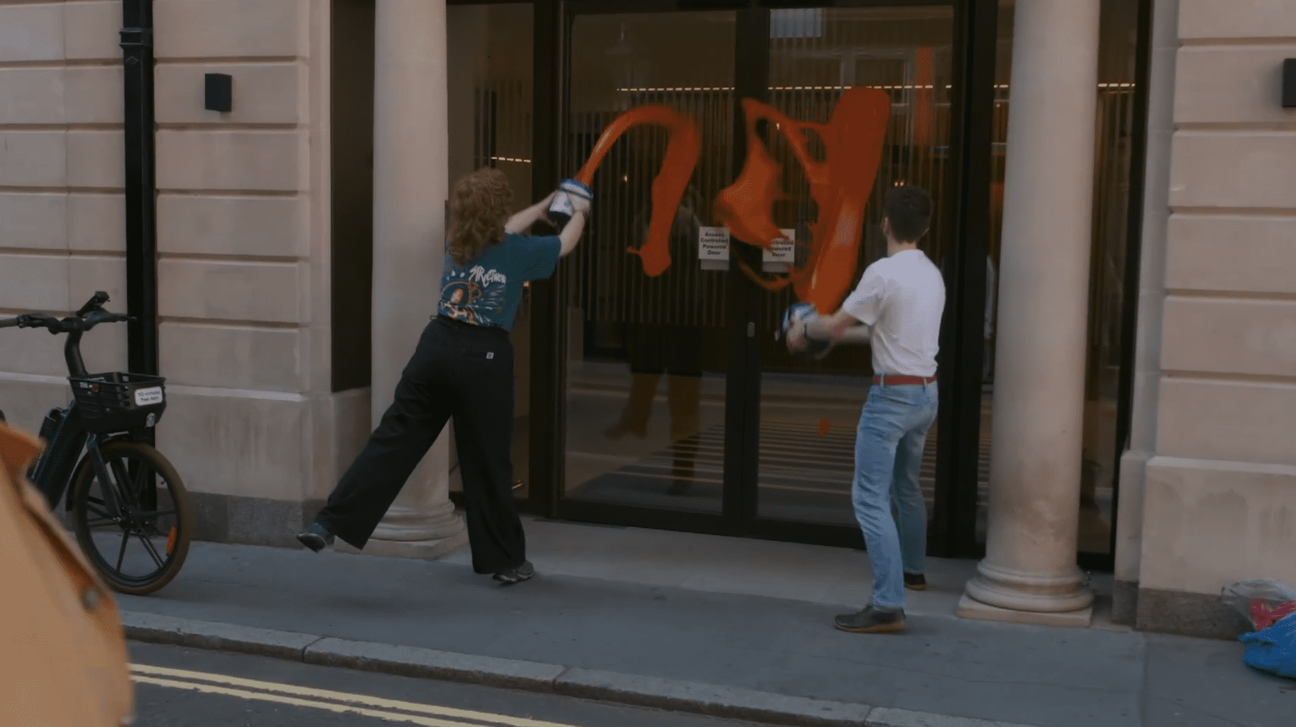 Just Stop Oil protestors throwing paint against a building