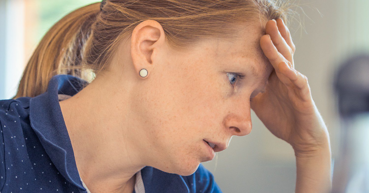 Woman with head in hands (Credit: Pexels)