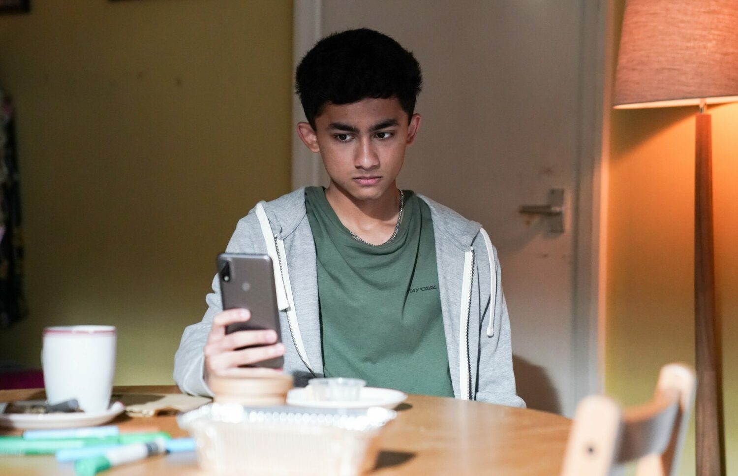 Angry Nugget in EastEnders looks at his phone.