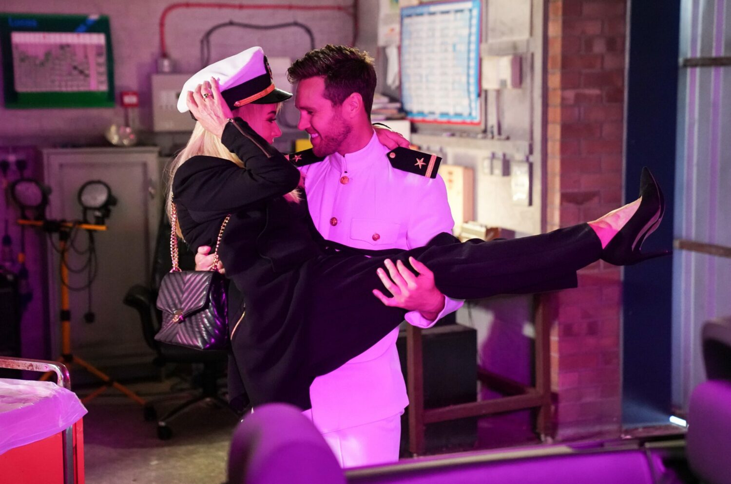 Keanu Taylor dressed as a sailor sweeps Sharon Watts into his arms as she wears his sailor hat