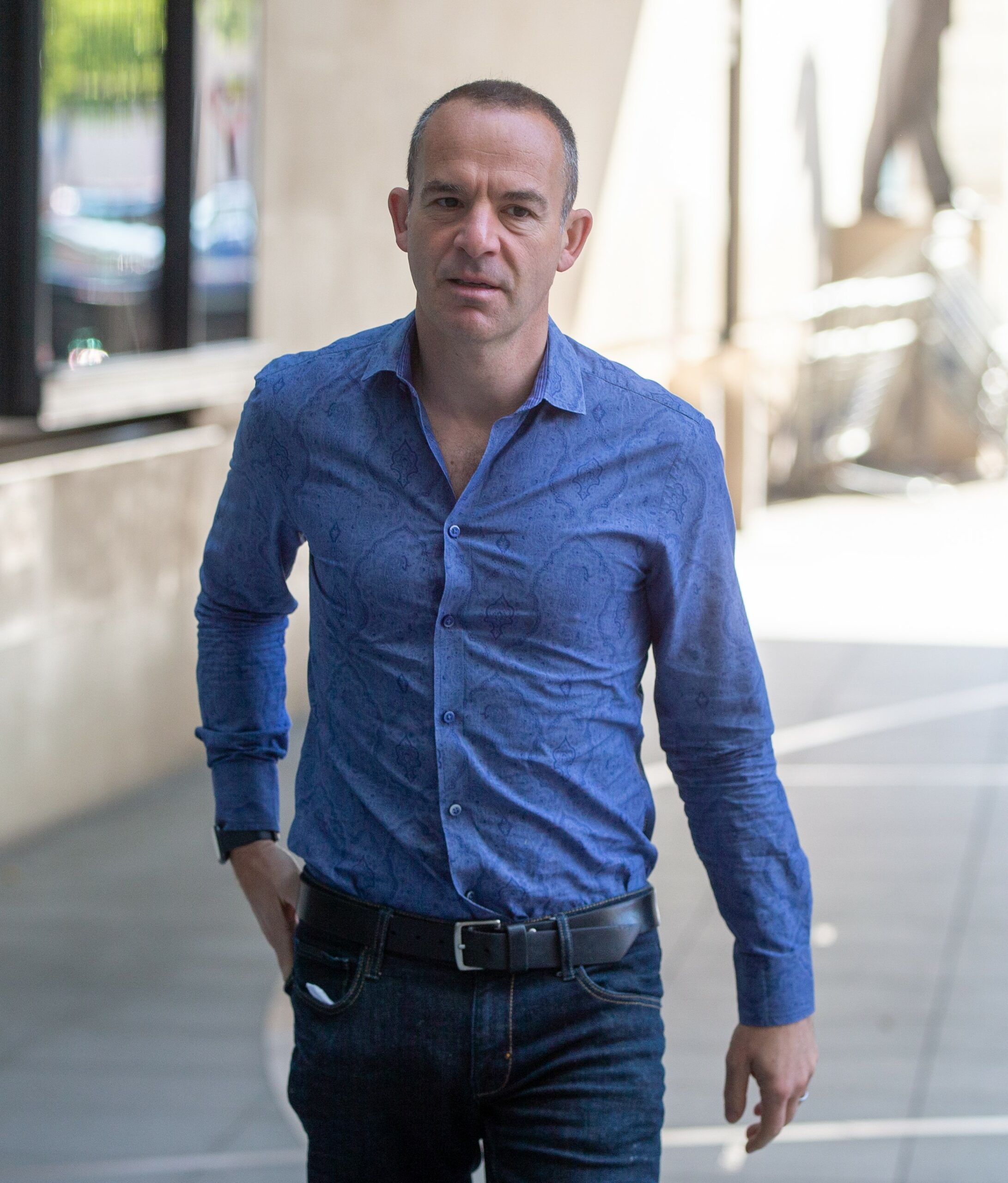 Martin Lewis walking in blue shirt outside BBC studios