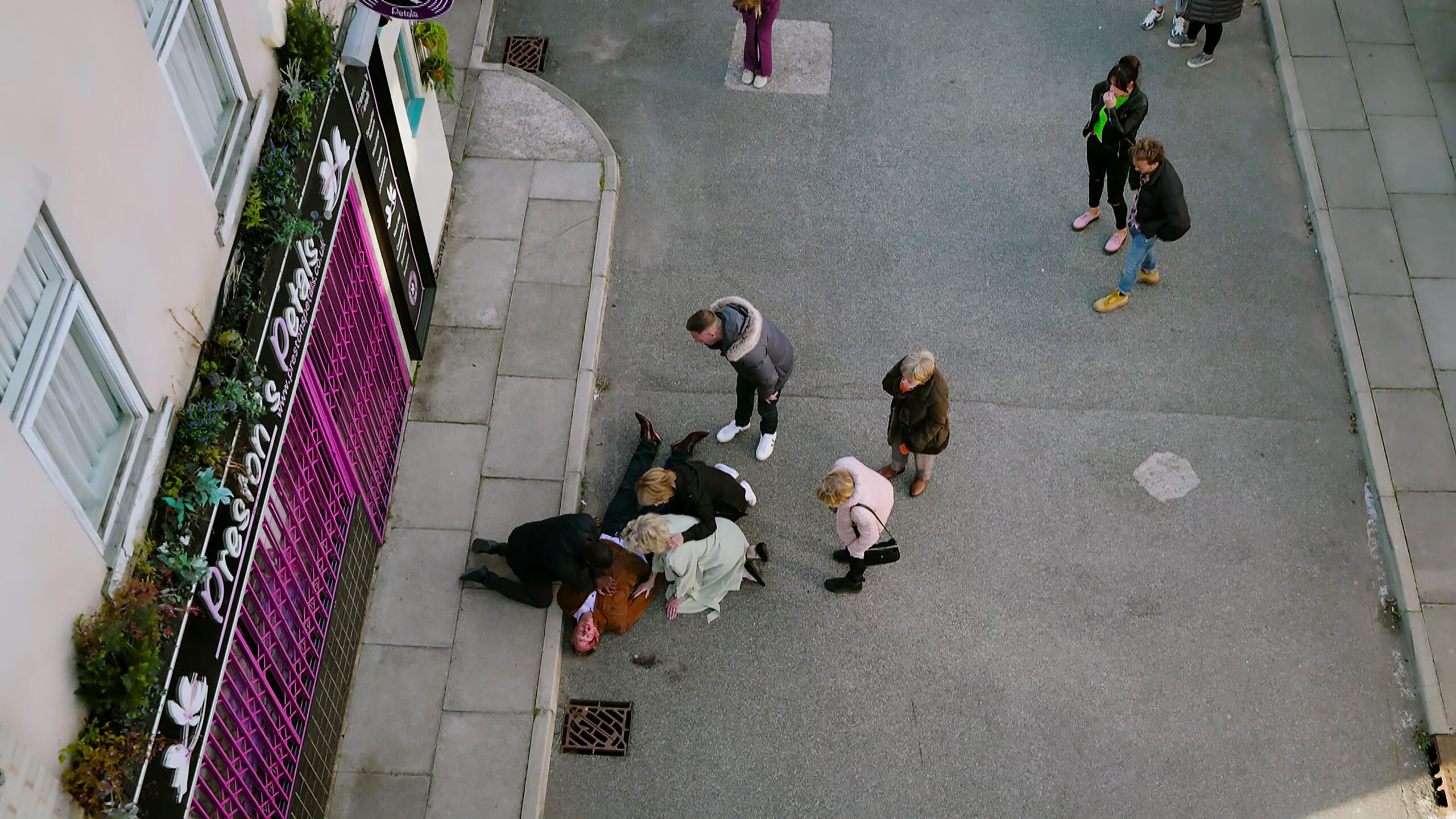 Stephen lying dead in the street on Corrie, surrounded by family and neighbours