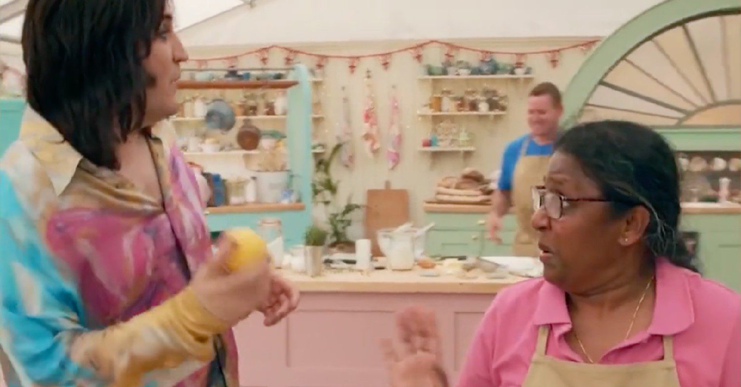 Noel Fielding holding a lemon and about to throw it while on the Great British Bake Off