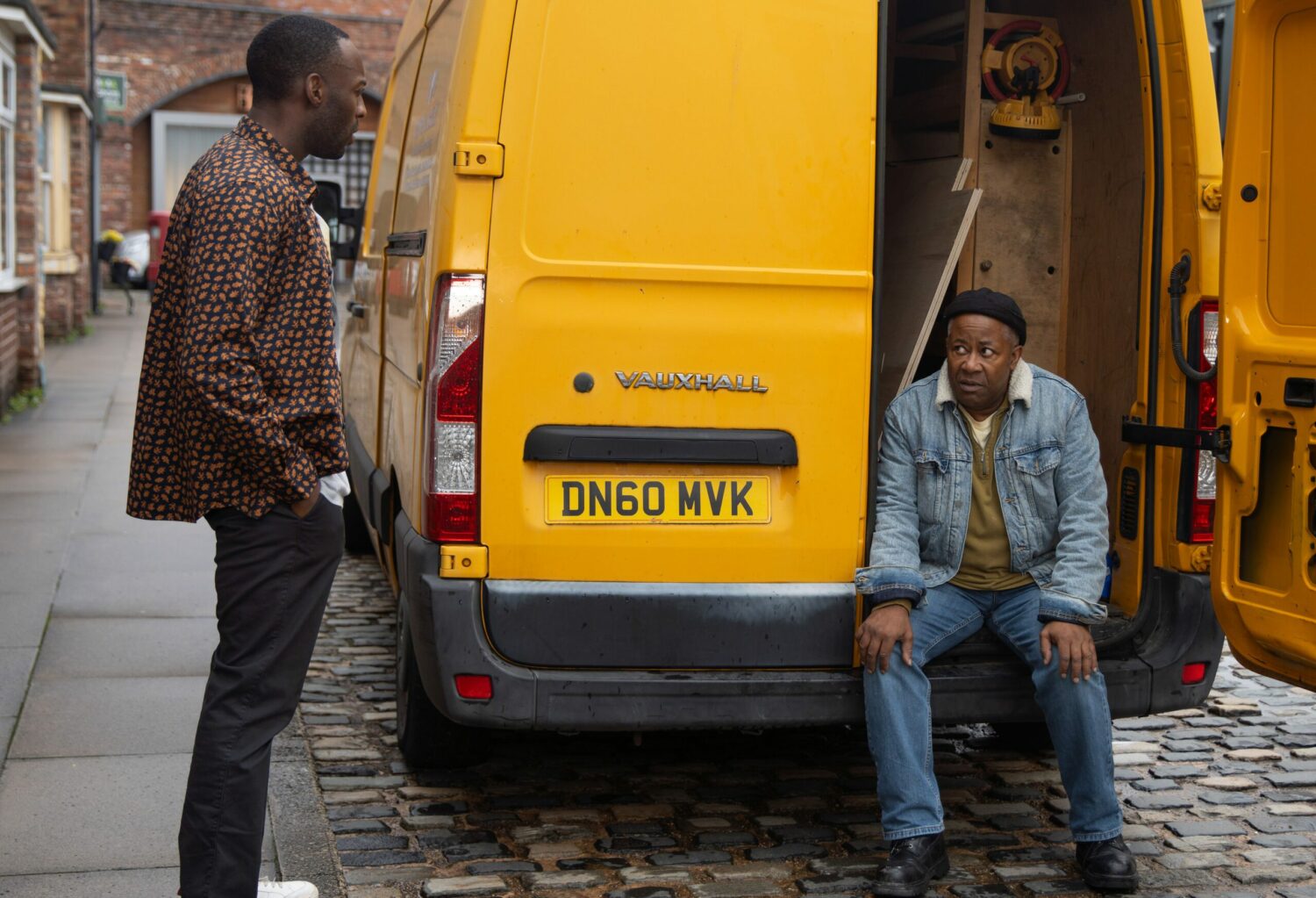 Ed in Corrie sits in the back on his van and looks worried as he talks to Michael