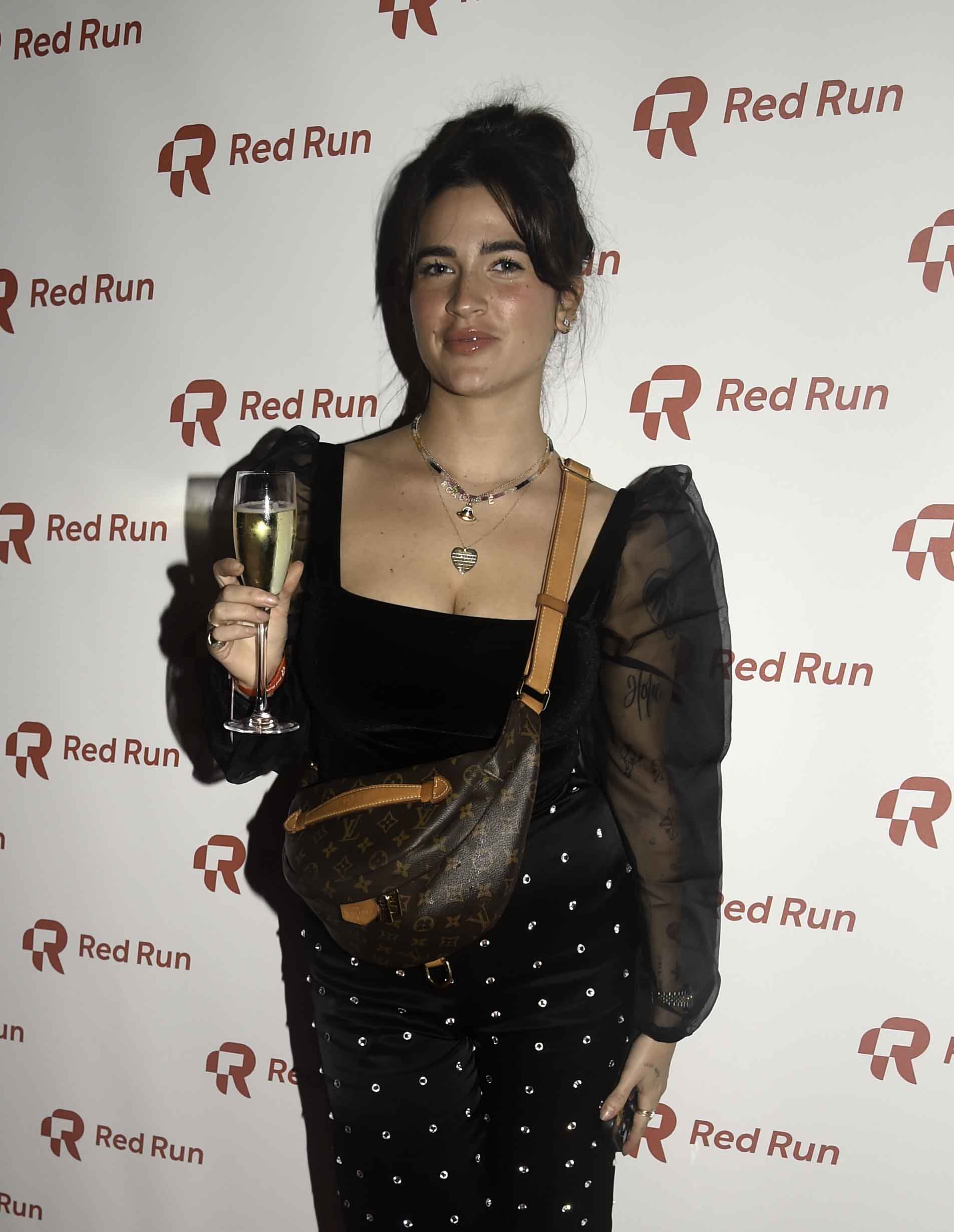 Boadecia Evans smiling holding a glass of champagne