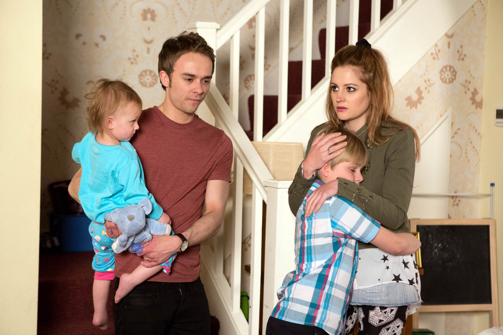 Kylie and David hug Max and Lily in the Platts' house in Coronation Street