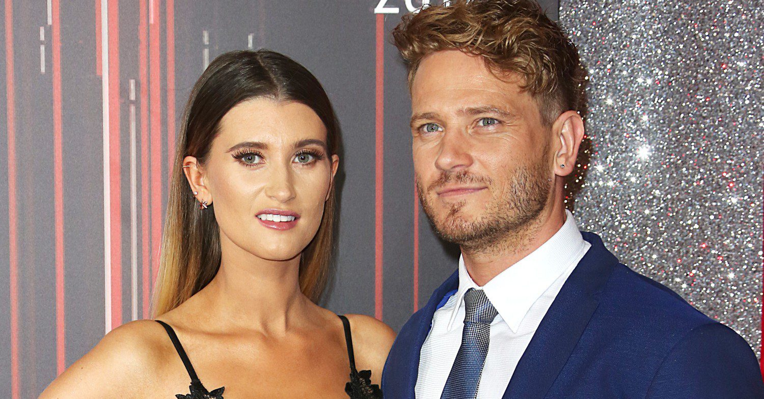 Charley Webb and Matthew Wolfenden posing on a red carpet