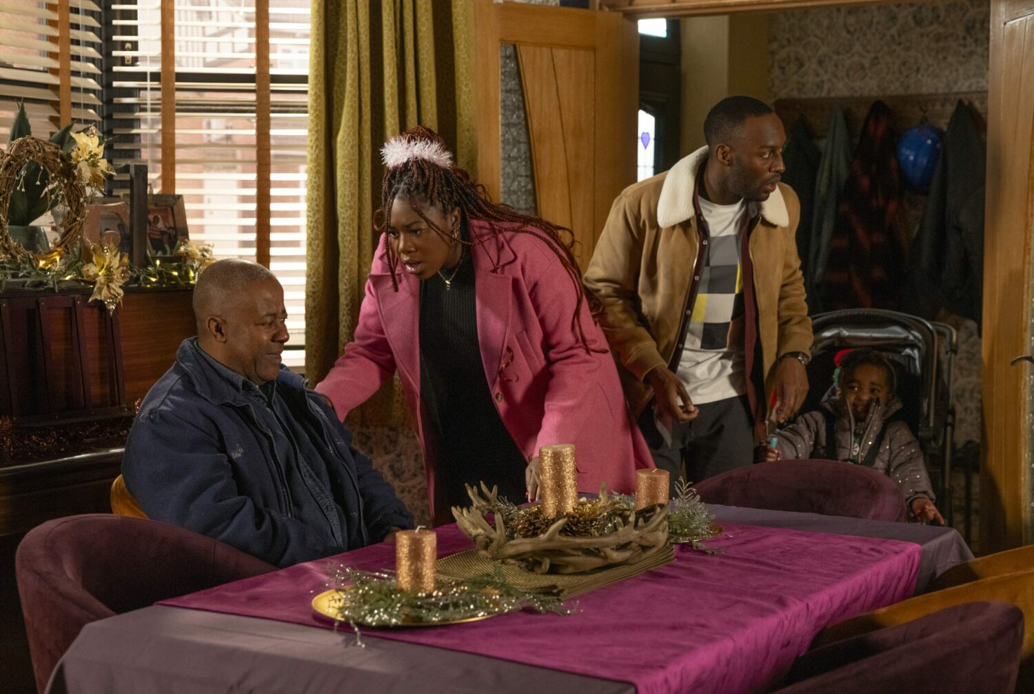 Corrie: Ed sits in a chair looking pained as worried Dee-Dee and Michael enter the house.