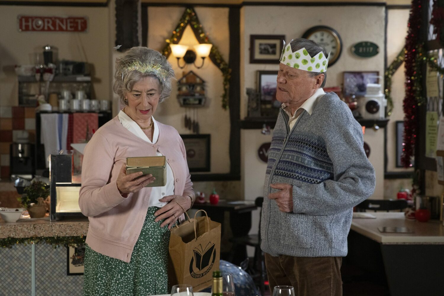 Evelyn looks lovingly at Roy's gift to her, a book, in Corrie