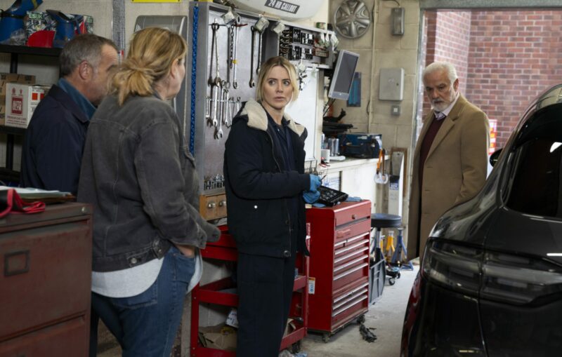 Cassie, Abi and Kevin in the garage with an angry Porsche owner on Corrie
