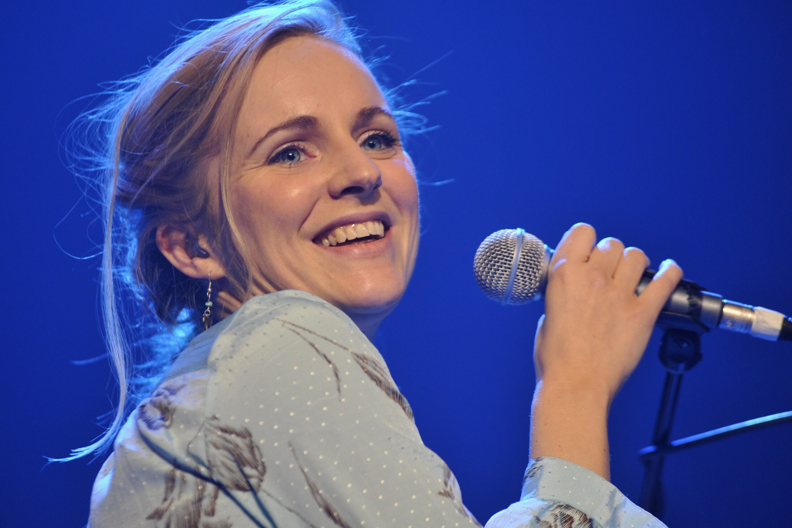Agnes Obel smiling and holding microphone