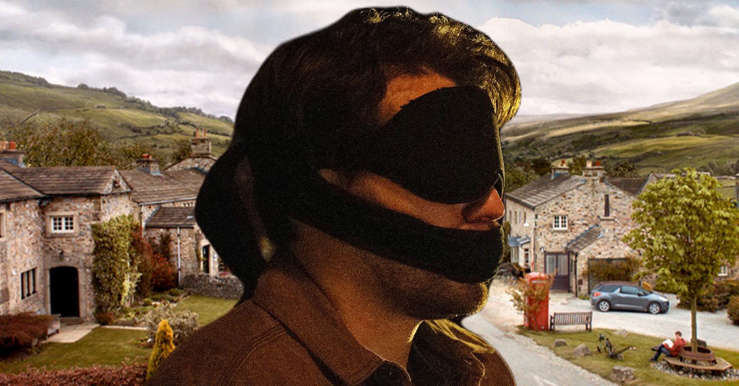 Emmerdale's Mack is tied up, blindfolded and gagged, the background of the Dales