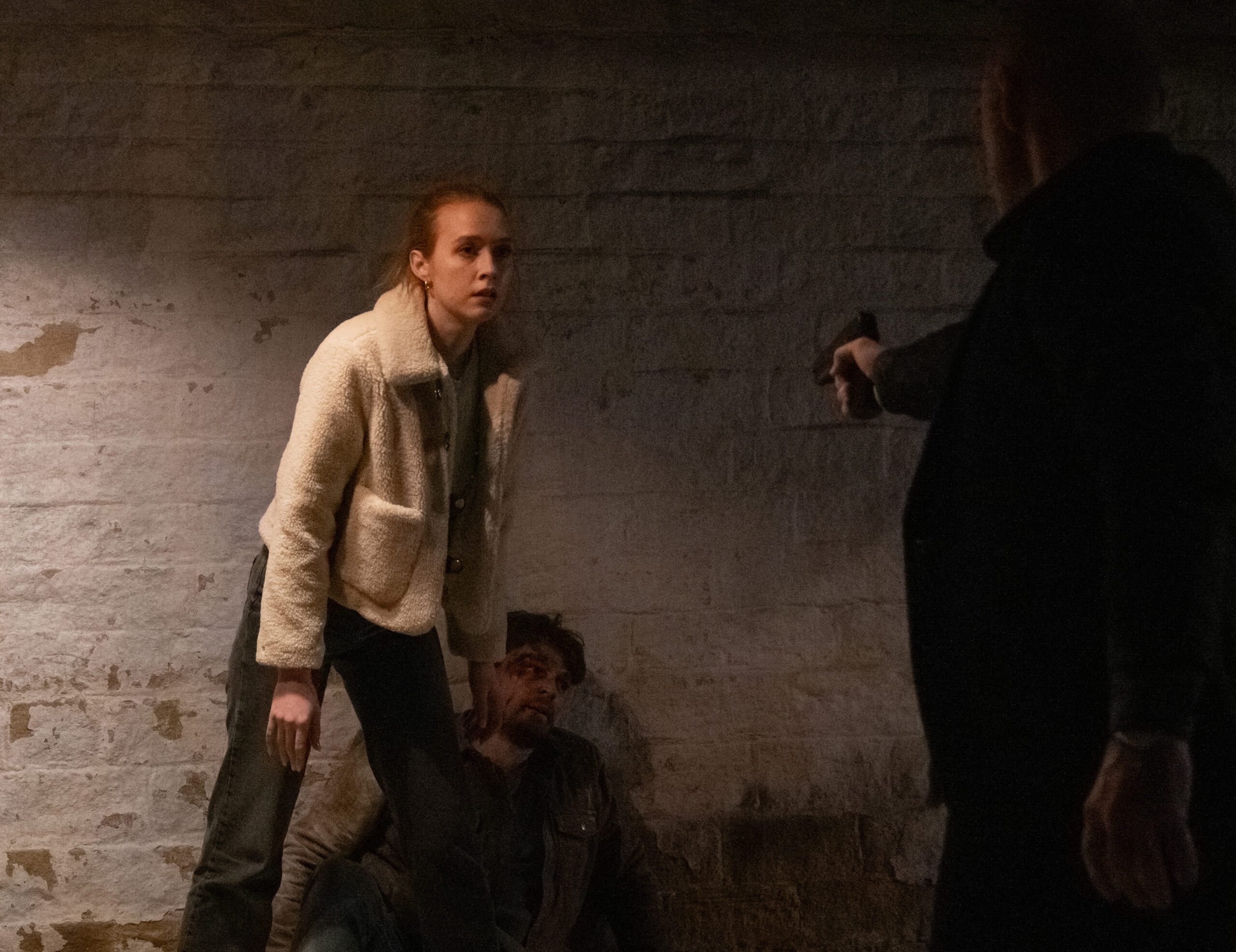 Emmerdale's Chloe has a gun pointed at her as she stands in front of Mack
