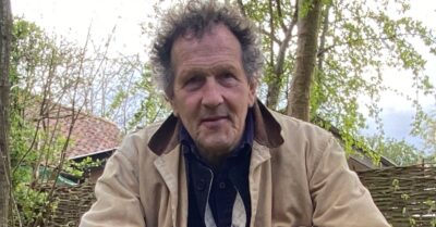 Monty Don in a beige coat in the garden