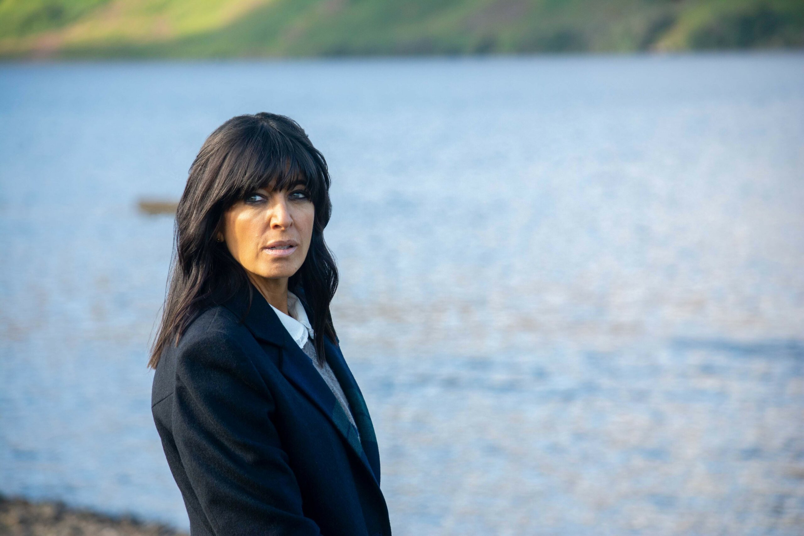 Claudia Winkleman standing next to a lake