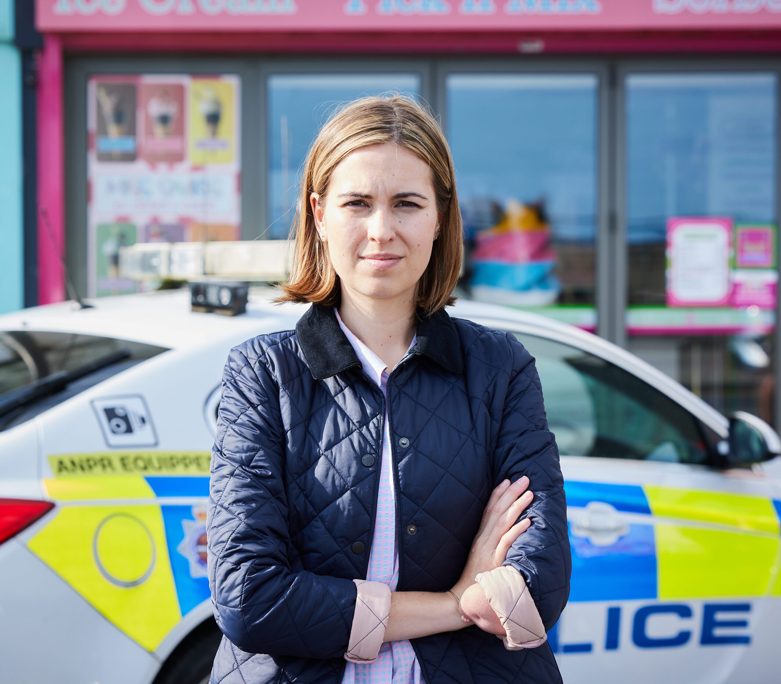 Rhiannon Clements as Steph Duncan standing in front of a police car in Vera