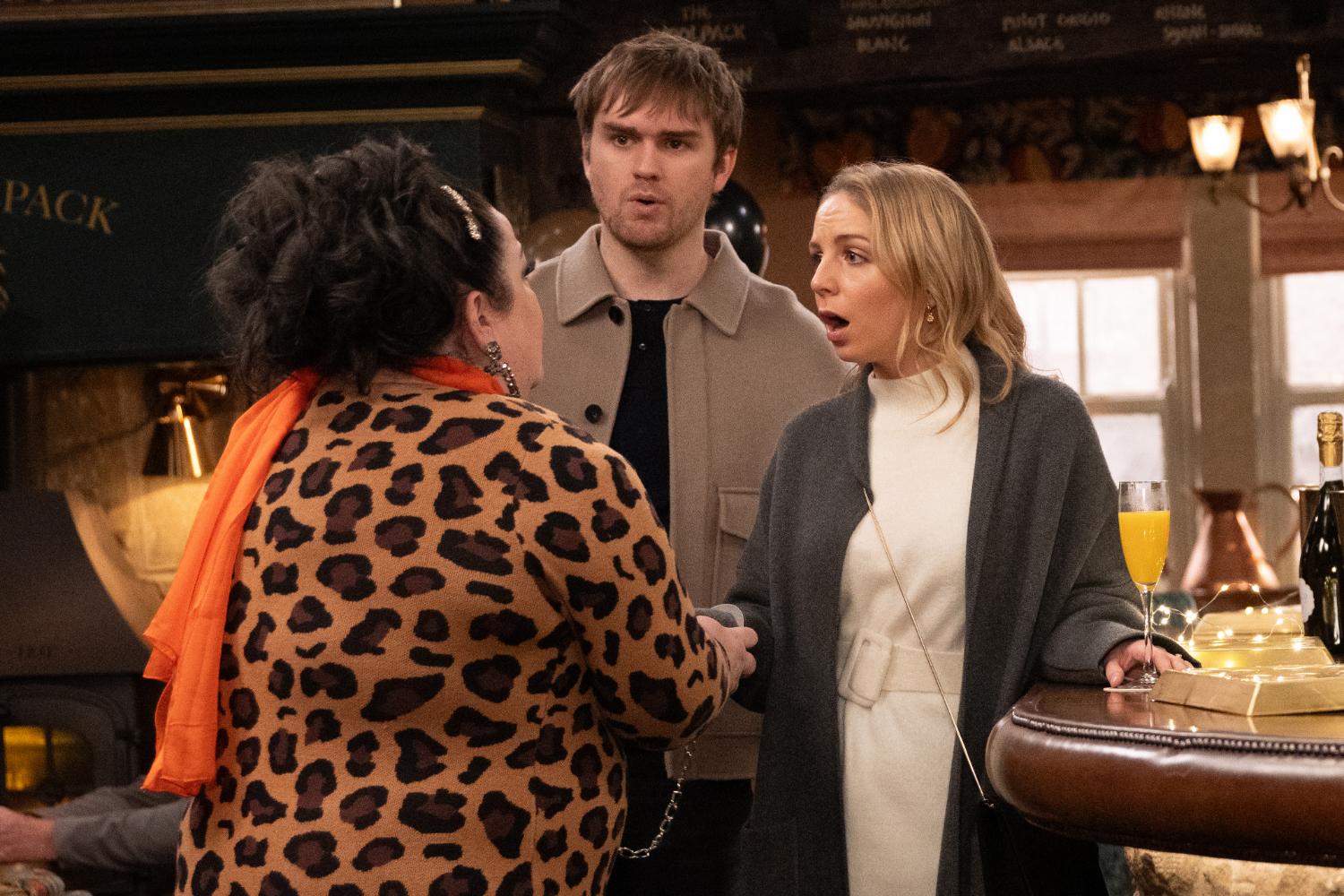 Tom and Belle look shocked in the Woolpack as Mandy handcuffs Belle