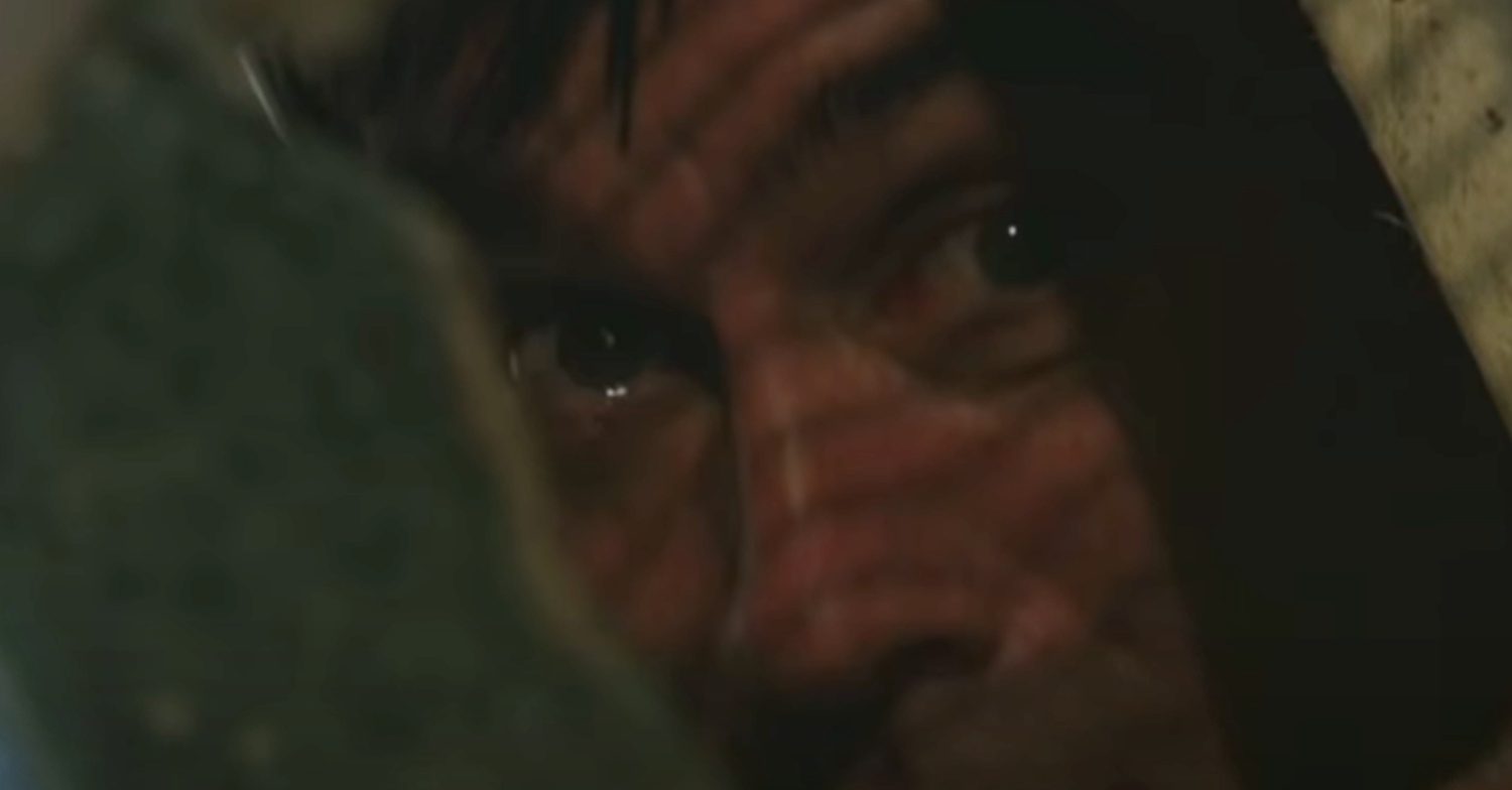 Emmerdale's Cain is peering through a gap in the wreckage