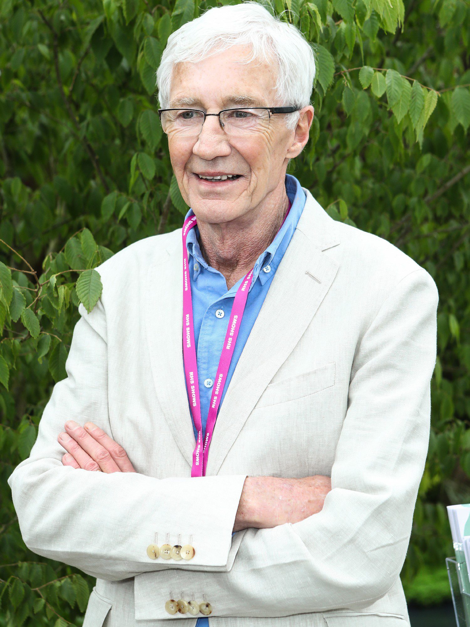 Paul O'Grady smiling with his arms folded