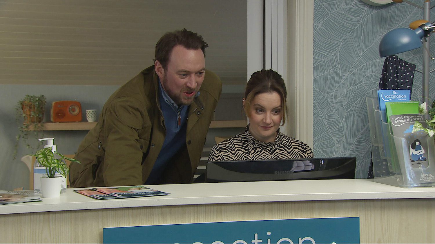 Dr Liam Cavanagh helps new receptionist Ella with the computer as they spark