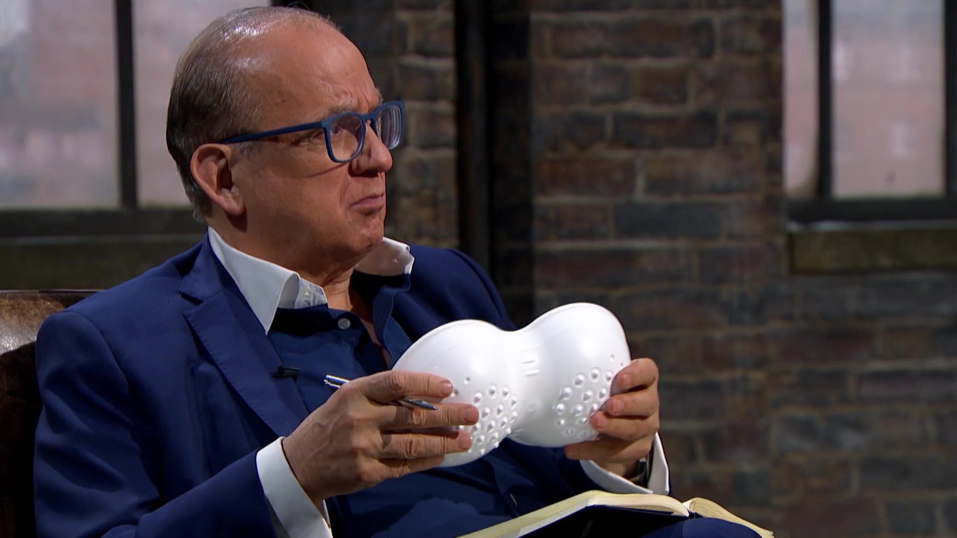 Touker Suleyman examines the product whilst listening to the entrepreneur on Dragons' Den