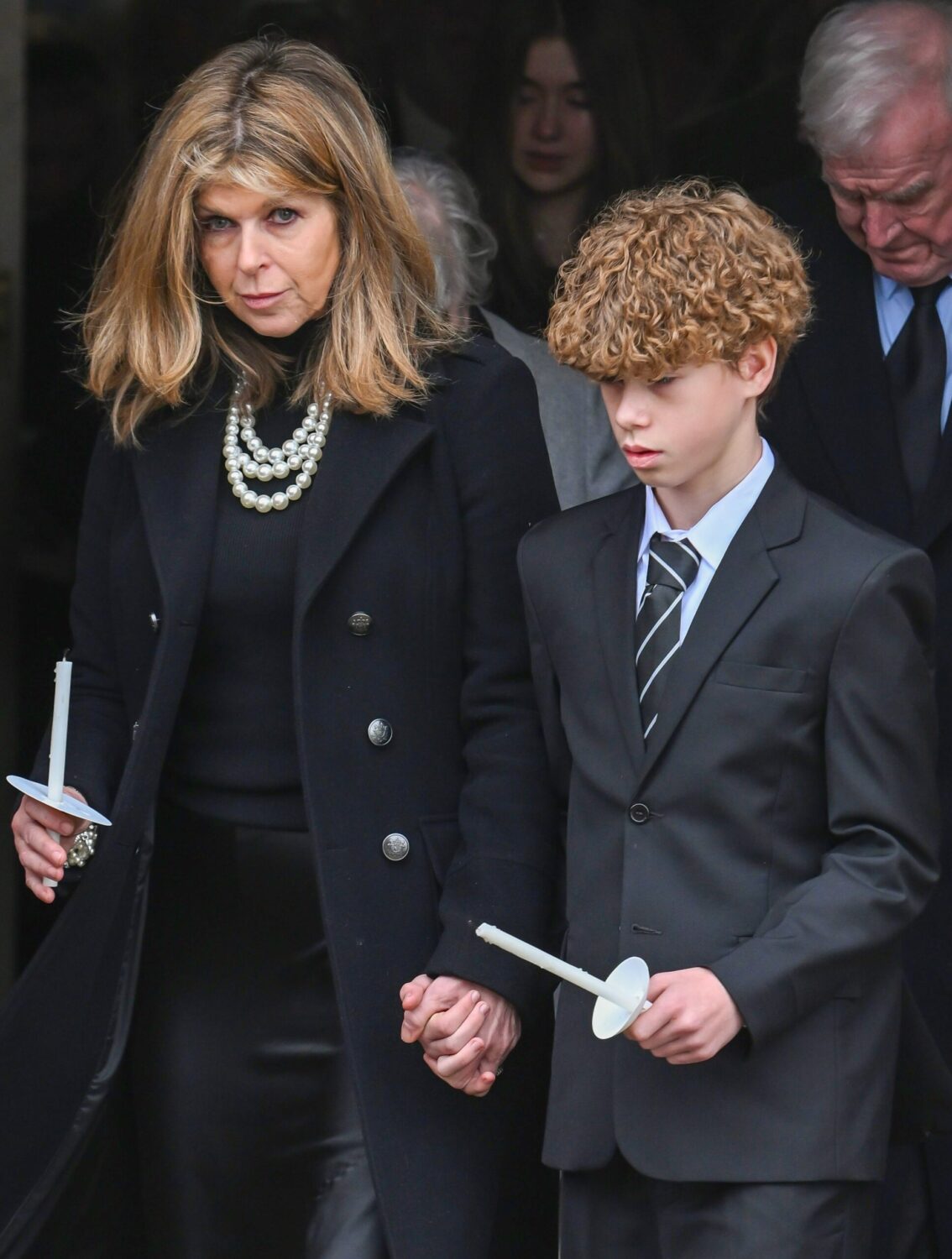 Kate Garraway and son Billy hold hands as they leave Derek Draper's funeral