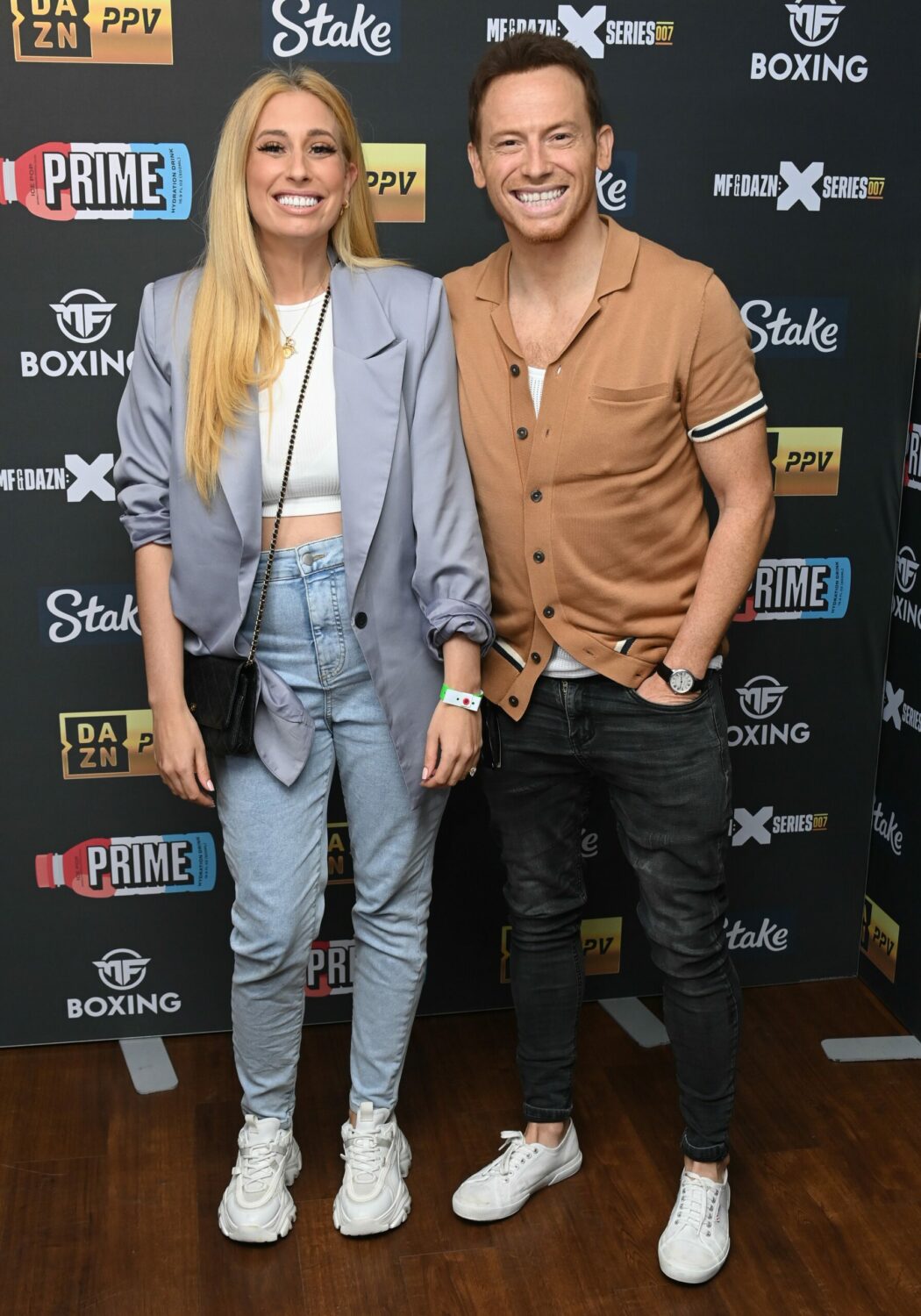 Stacey Swash and Joe Solomon have six kids between them - they smile together in front of a branding board