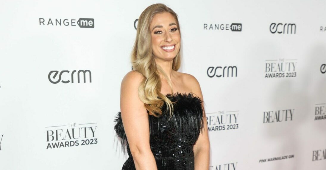 Stacey Solomon smiles on the red carpet in a black feathered dress