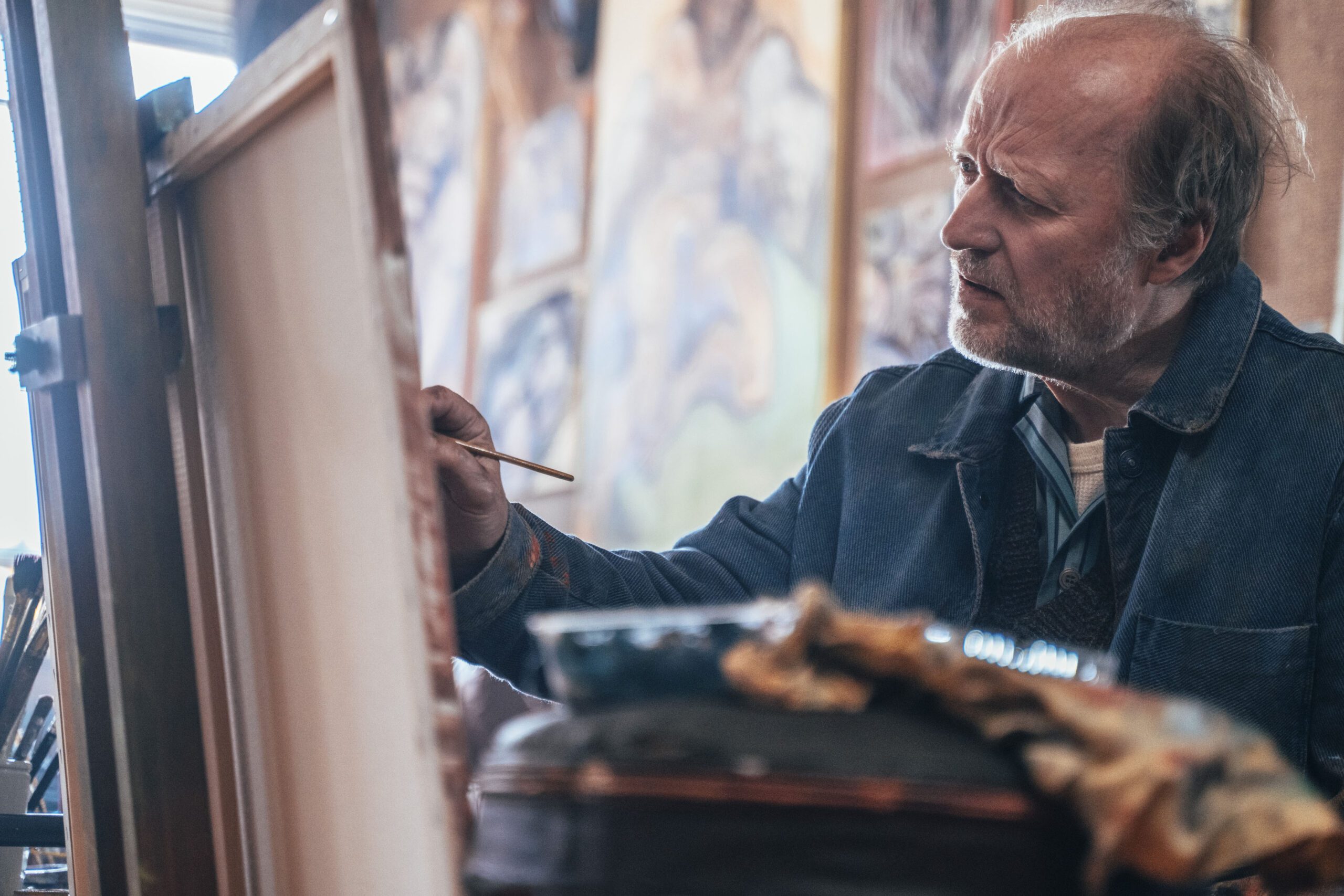 Adrian Edmondson as Lenny in Rain Dogs, concentrating on painting 