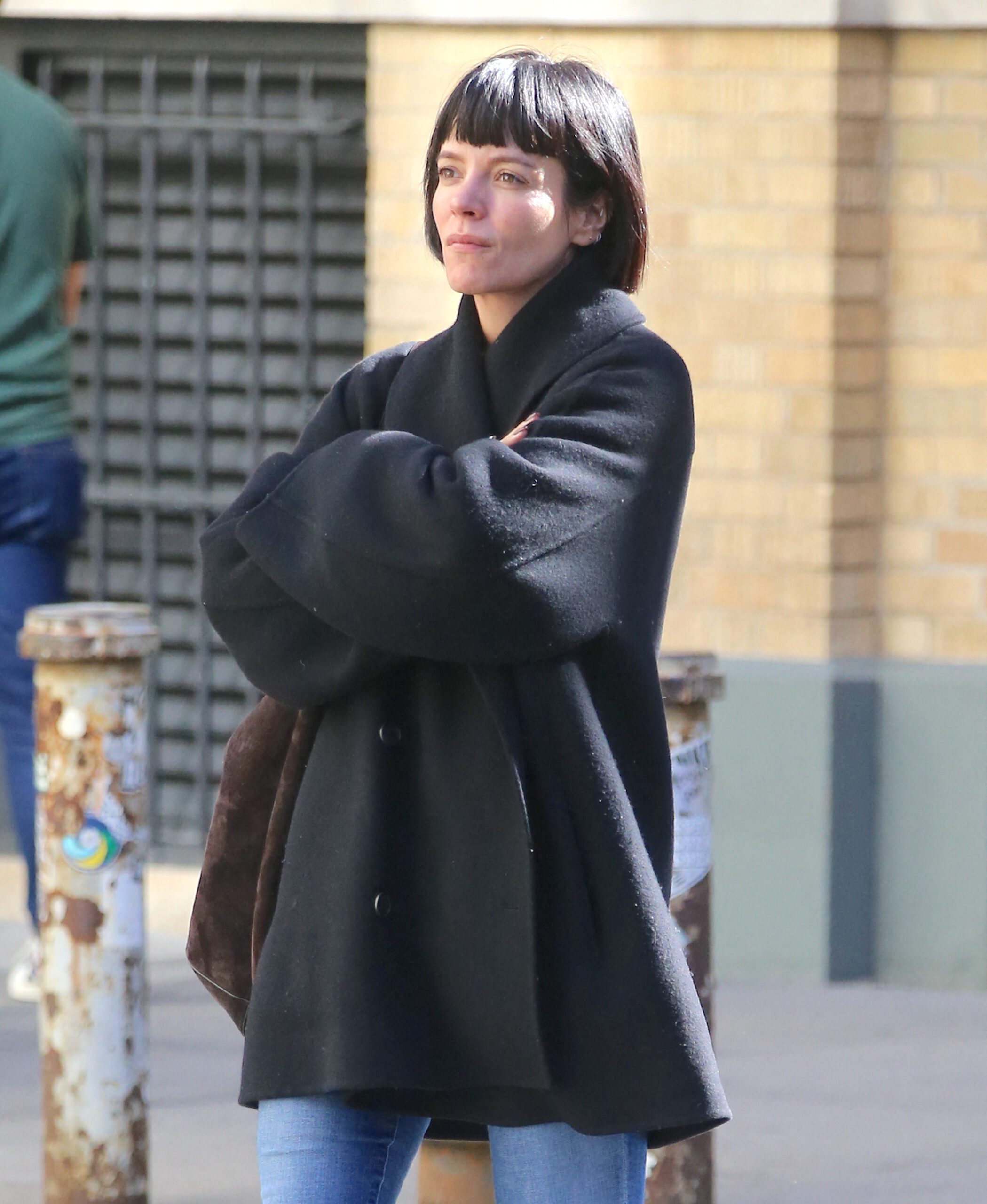 Lily Allen with short black bob hair in a black coat