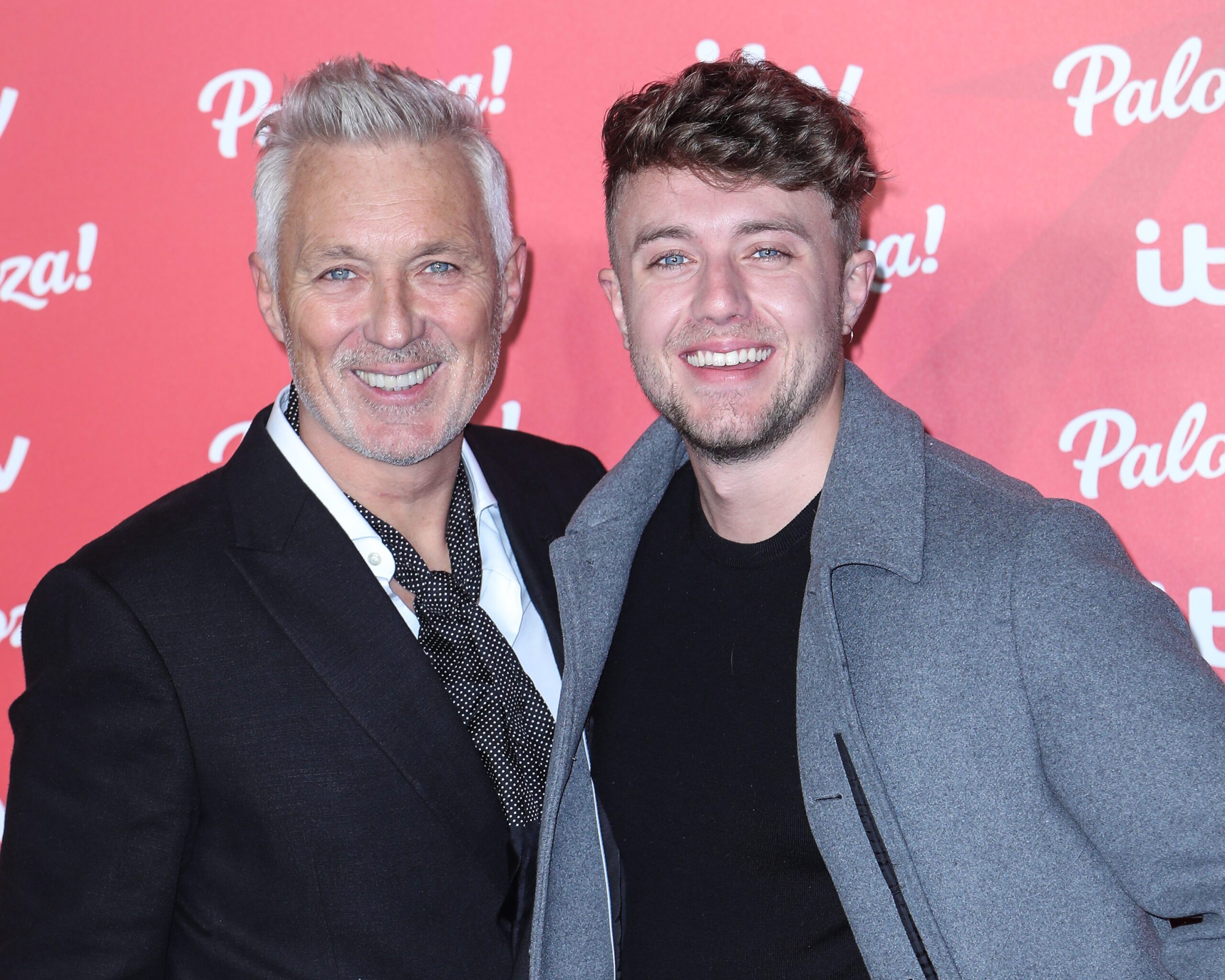 Martin and Roman Kemp smiling against a pink backdrop