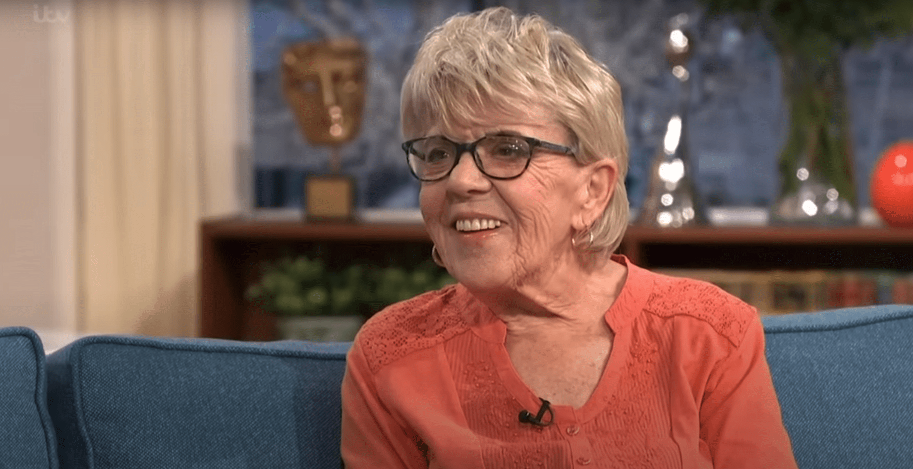 Iris Jones smiling on This Morning in an orange top