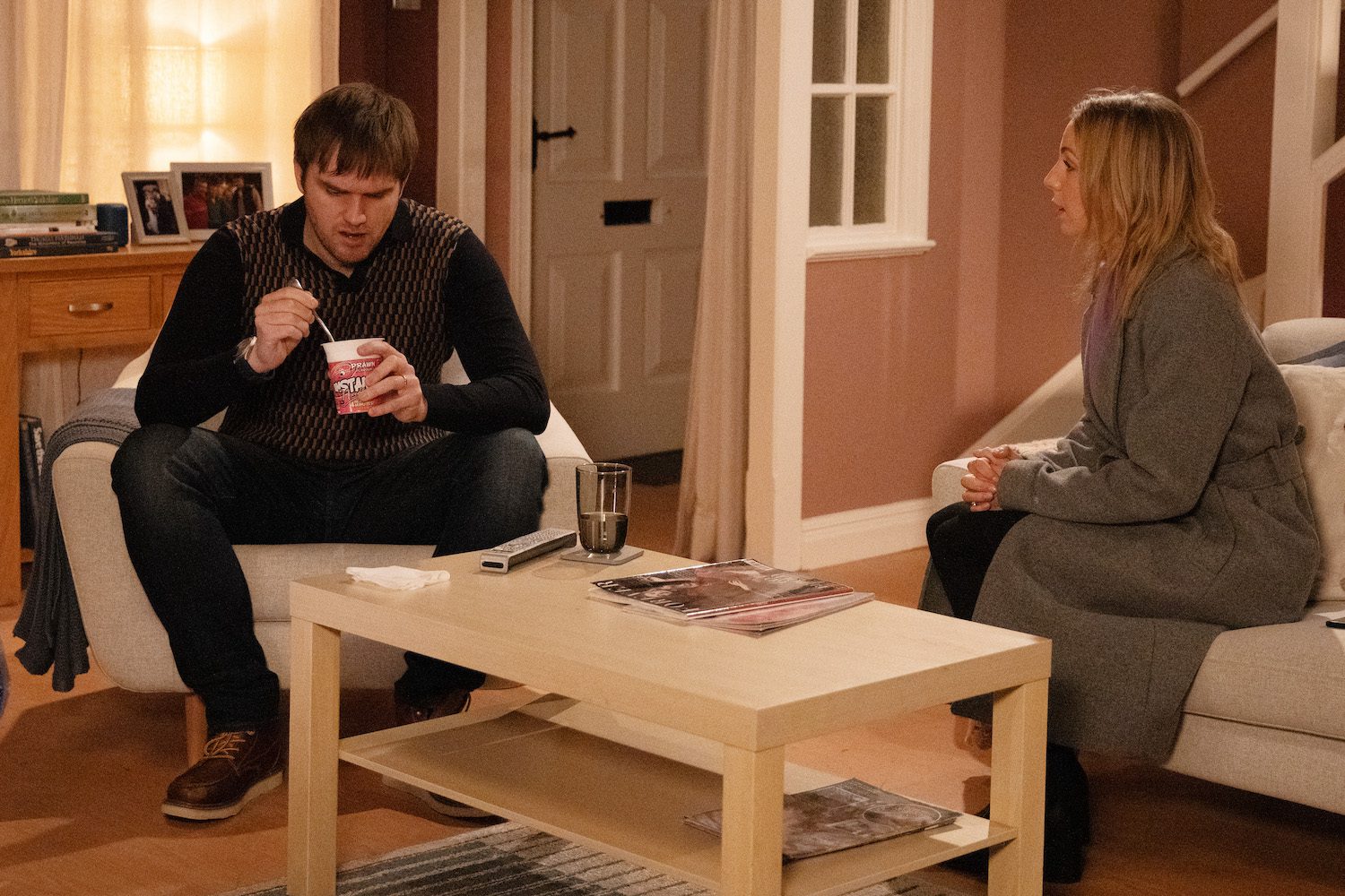 Tom looks sulky as Belle talks to him on Emmerdale