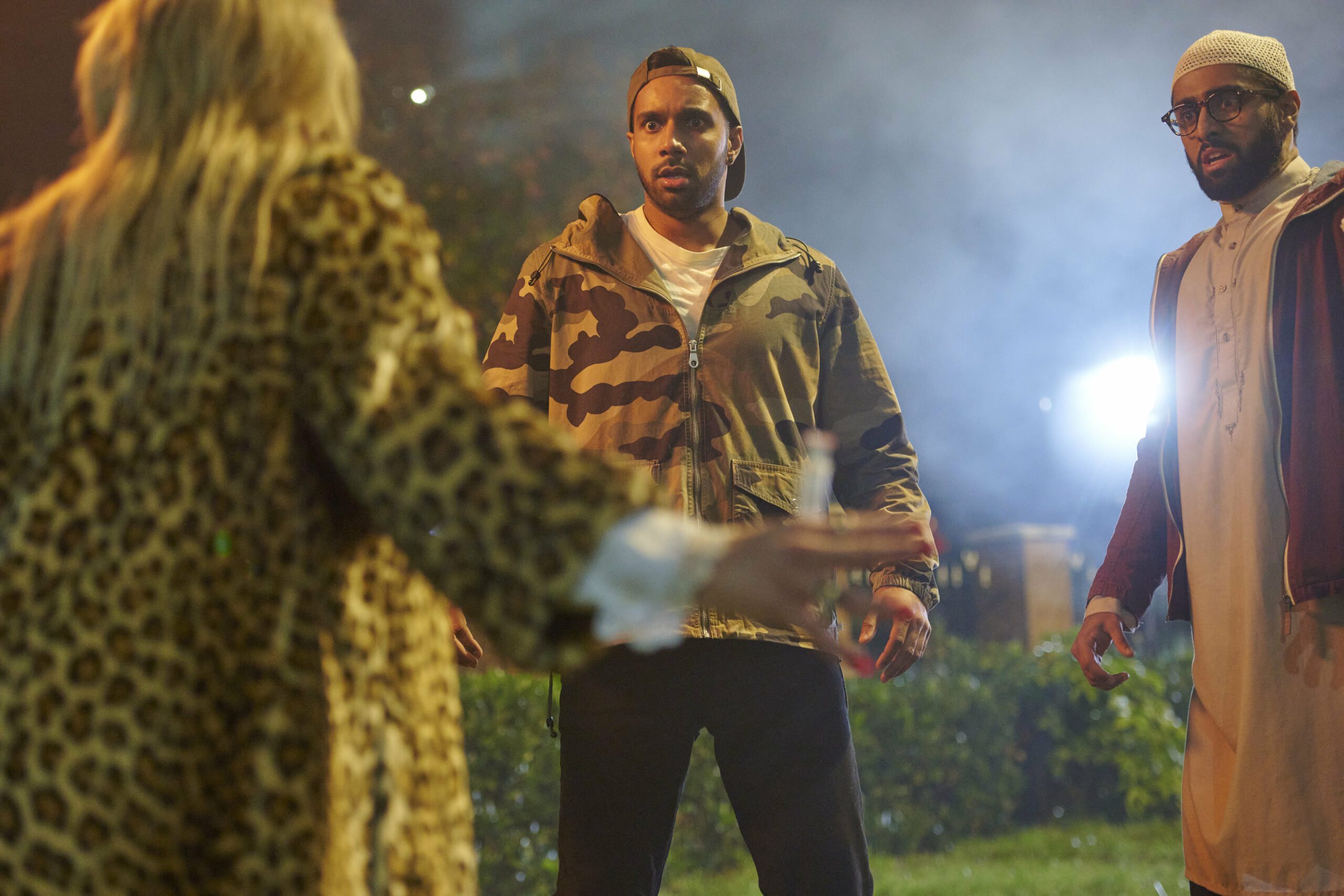 Rishi Nair (centre) looking surprised at the woman in a long animal print coat in front of him in ITV's Count Abdullah