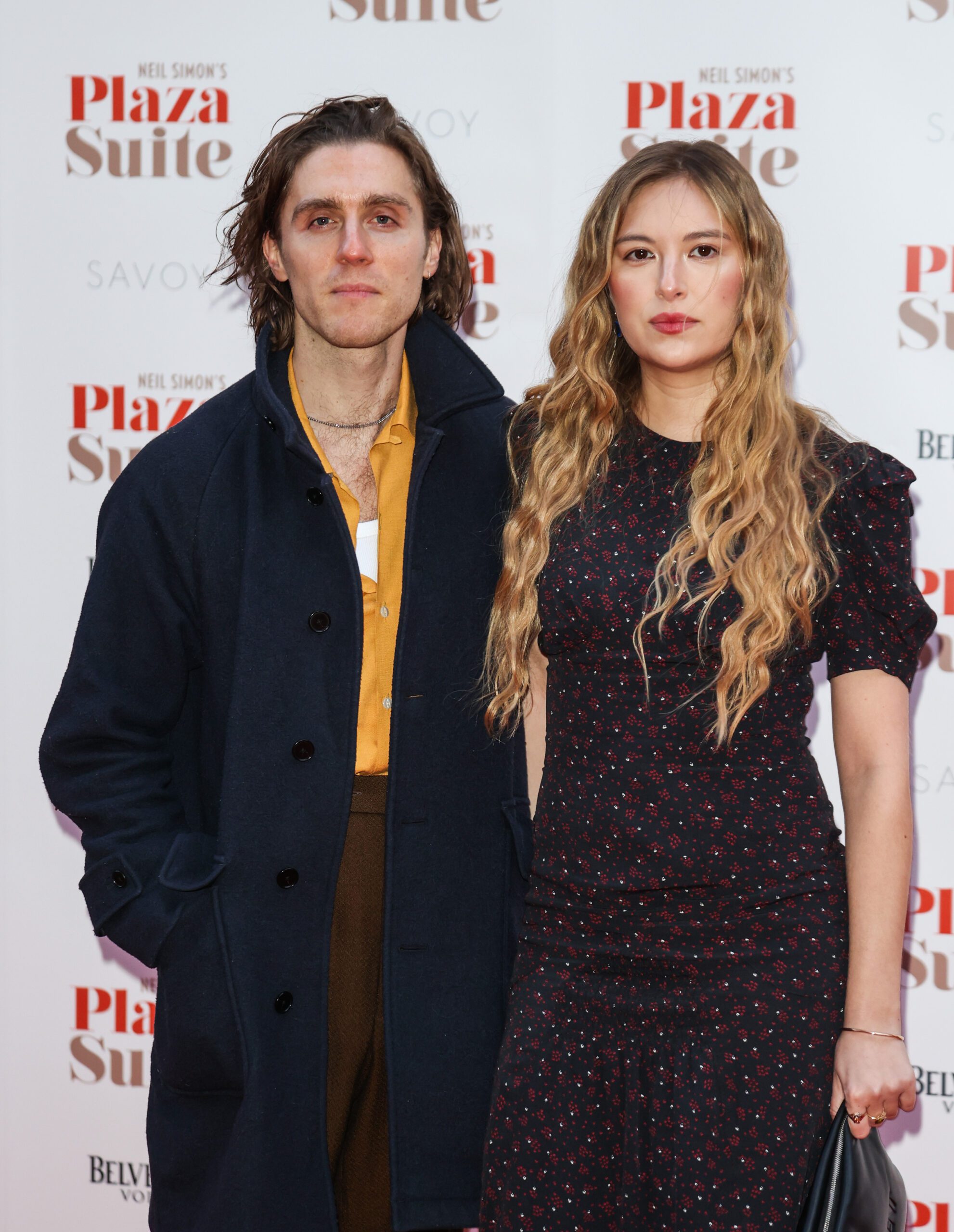 Jack Farthing and Hanako Footman looking directly at the camera and posing together at a gala performance of "Plaza Suite" at The Savoy Theatre in London