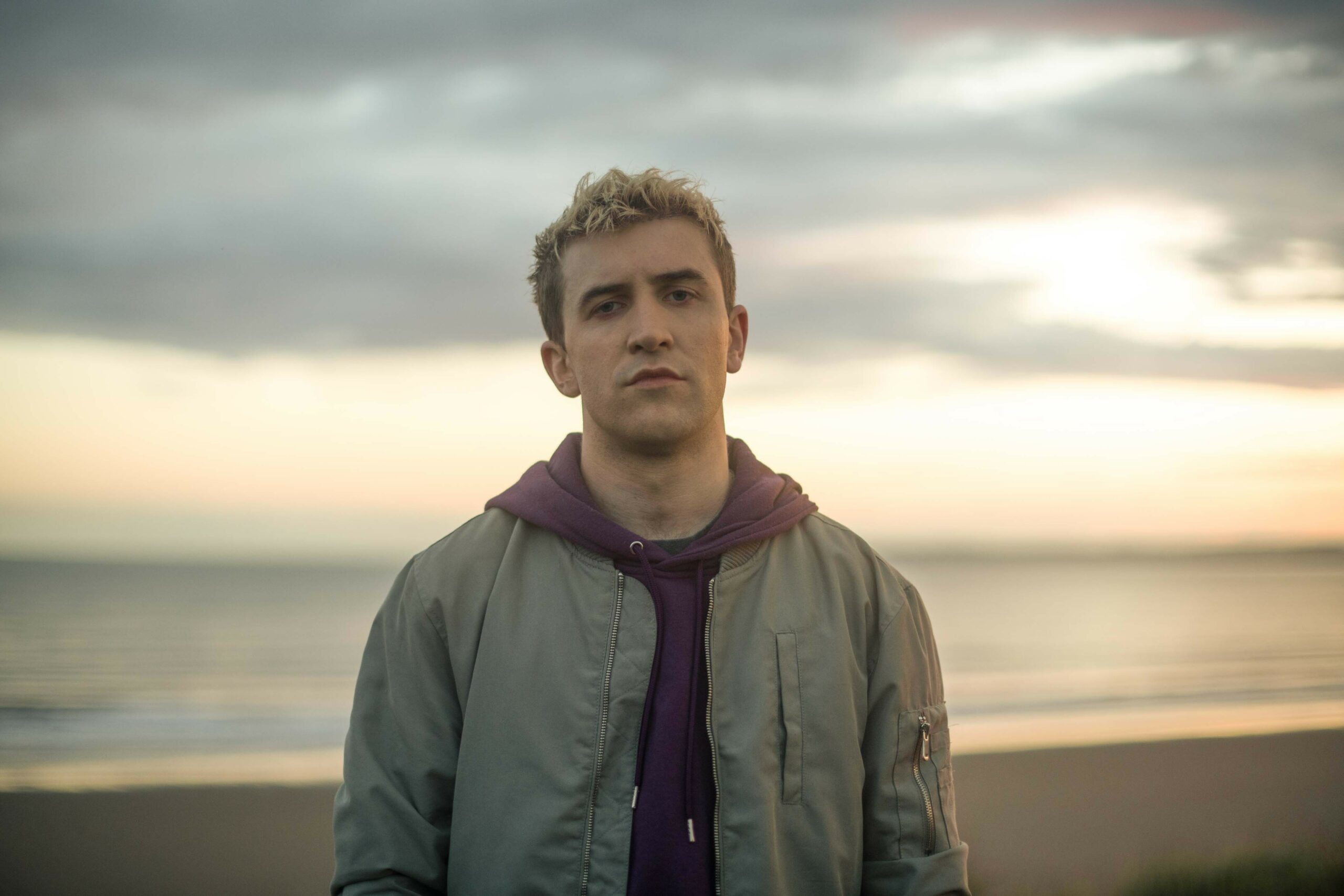 The Way cast: Callum Scott Howells as Owen Driscoll, with clouds and sunset in background