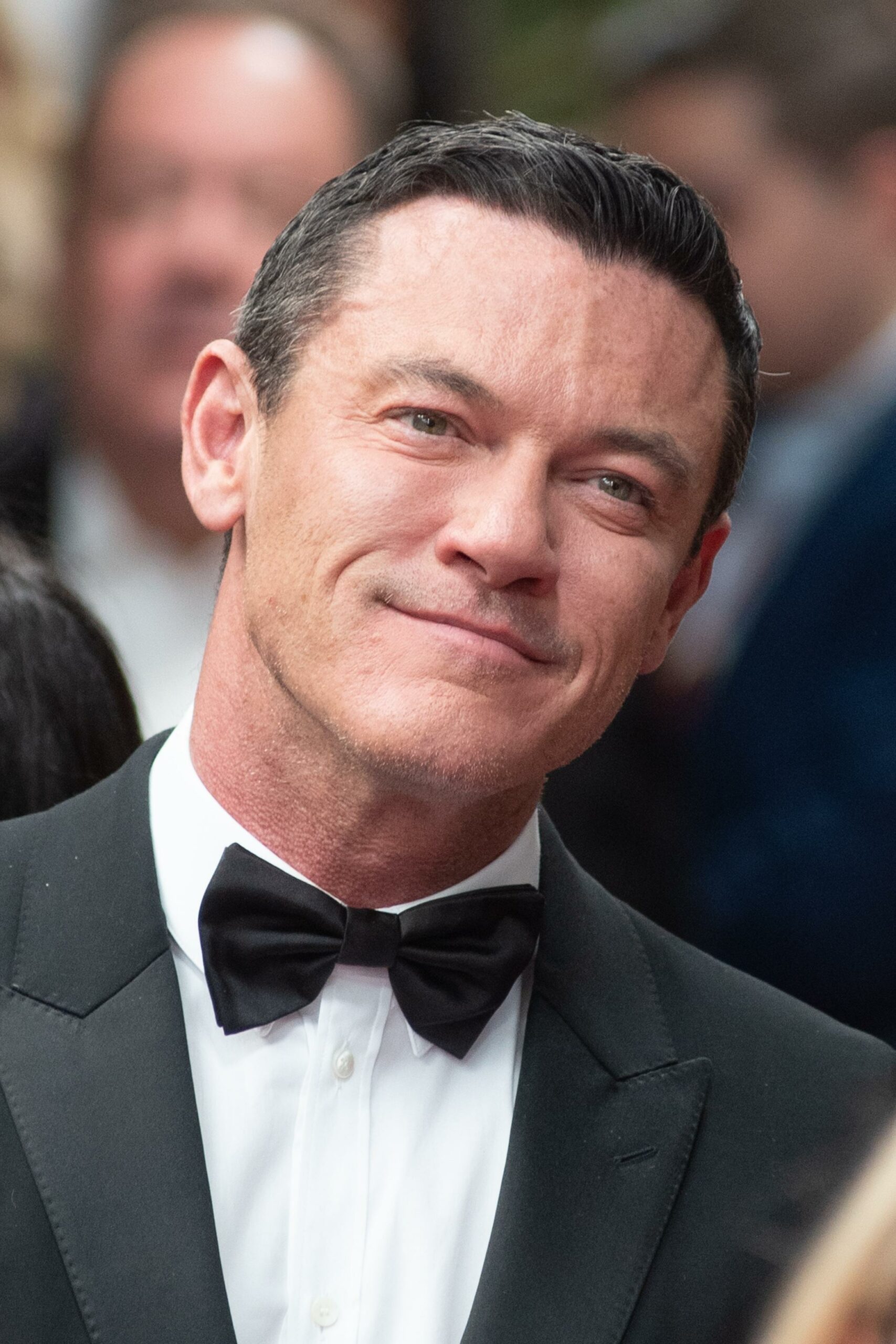 Luke Evans smiling, wearing a suit at the 76th Annual Tony Awards